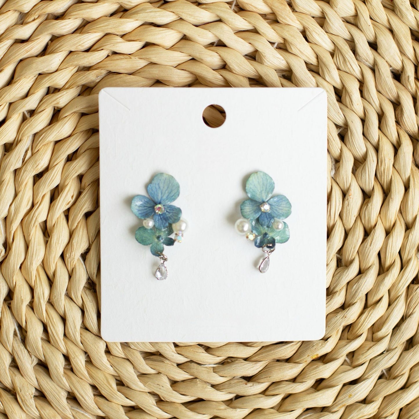 Hydrangea blue hydrangea earrings with resin petals on natural woven texture by Terra Decode