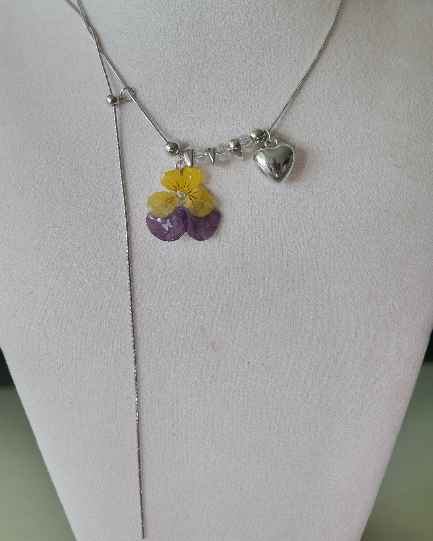 Full-length view of pansy heart lariat necklace with extended chain tail