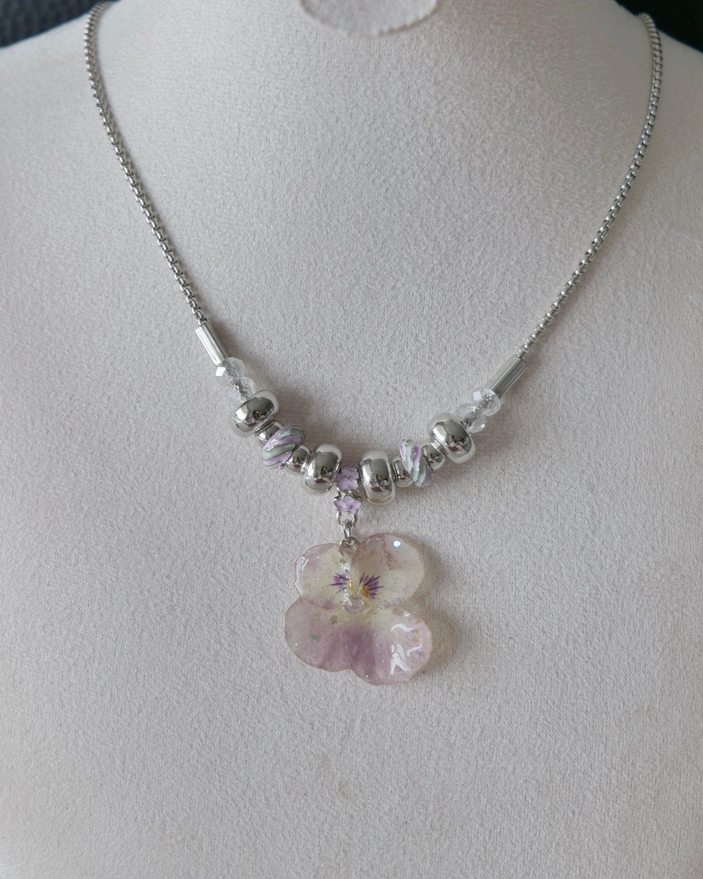 Side-front view of beaded pansy necklace with clear faceted accents