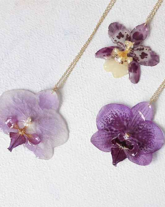 Soft purple orchid necklace variations with resin flower pendants and gold-tone chains by Terra Decode