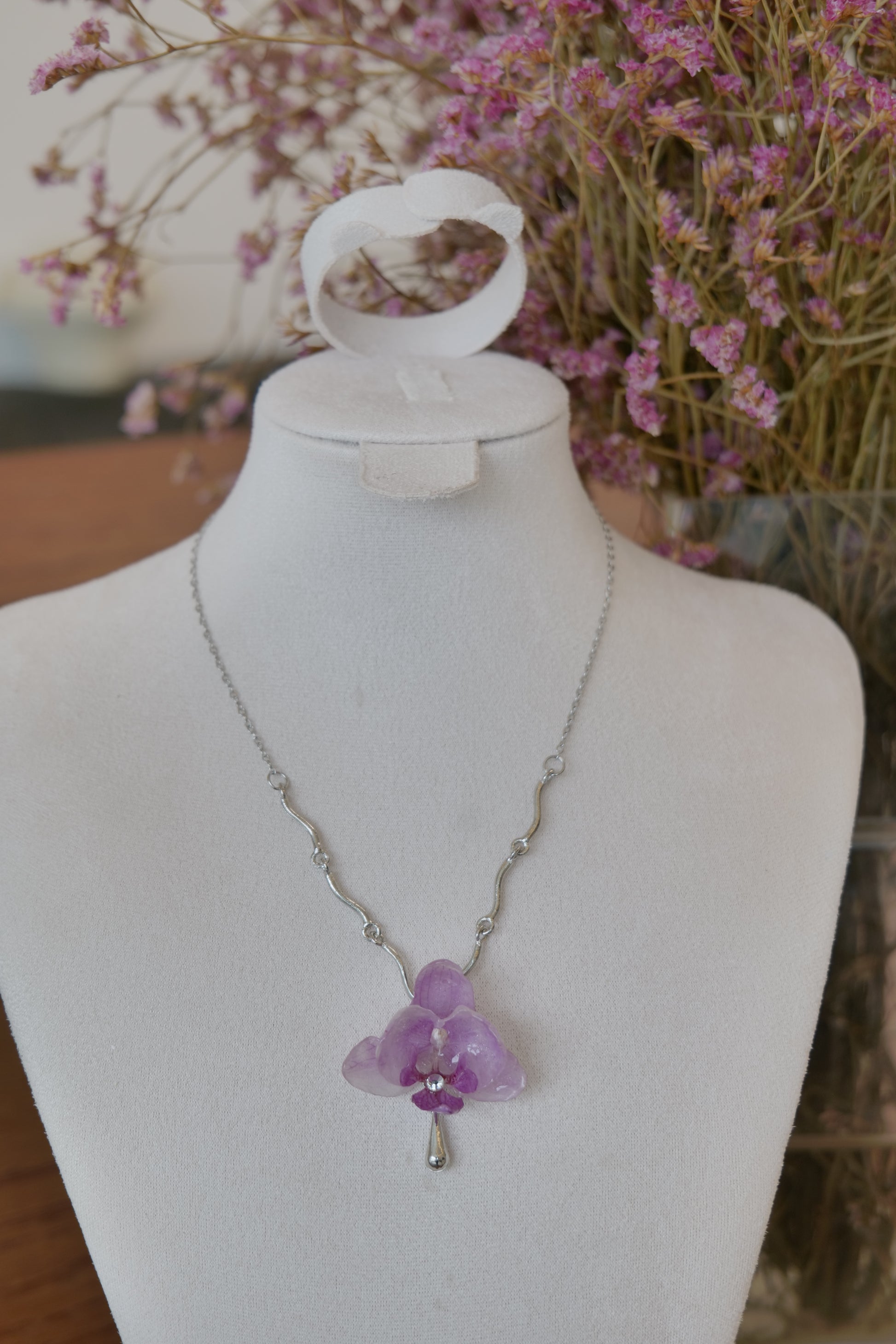 front view of purple Phalaenopsis orchid charm necklace, handmade botanical jewellery by Terra Decode