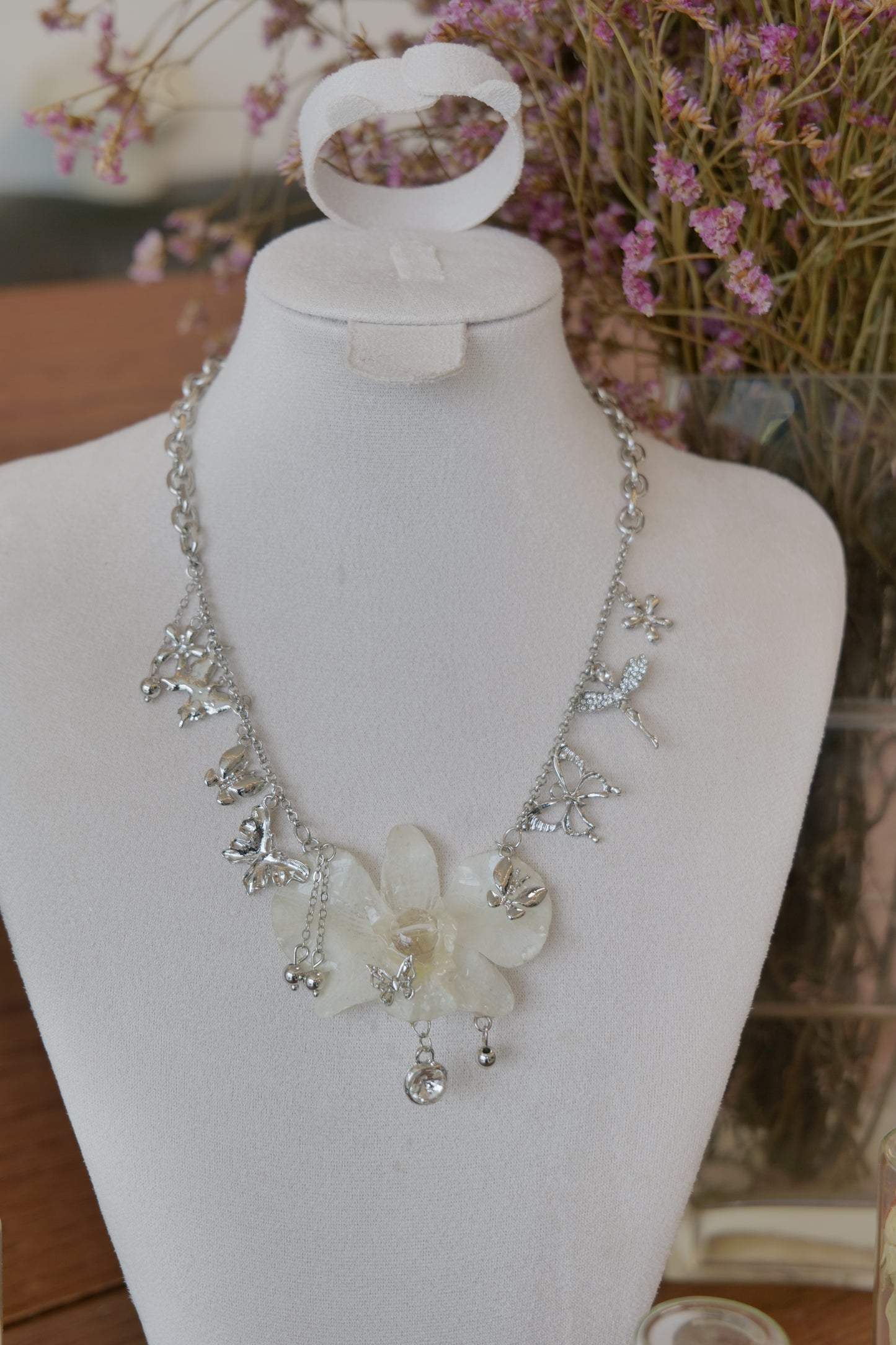 styled front view of white Dendrobium orchid statement necklace, handmade botanical jewellery by Terra Decode