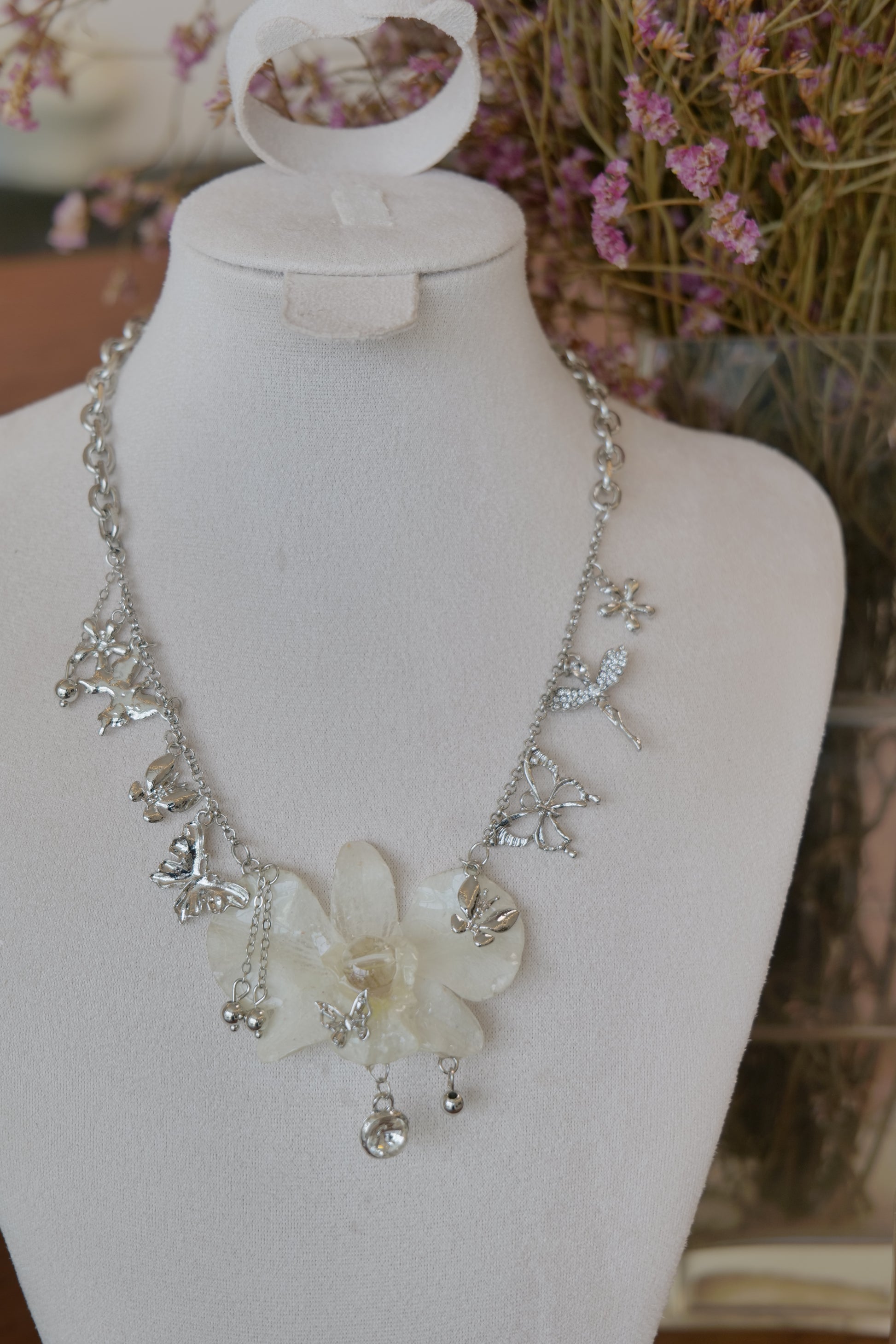 chain and charm detail of white Dendrobium orchid statement necklace, handmade botanical jewellery by Terra Decode