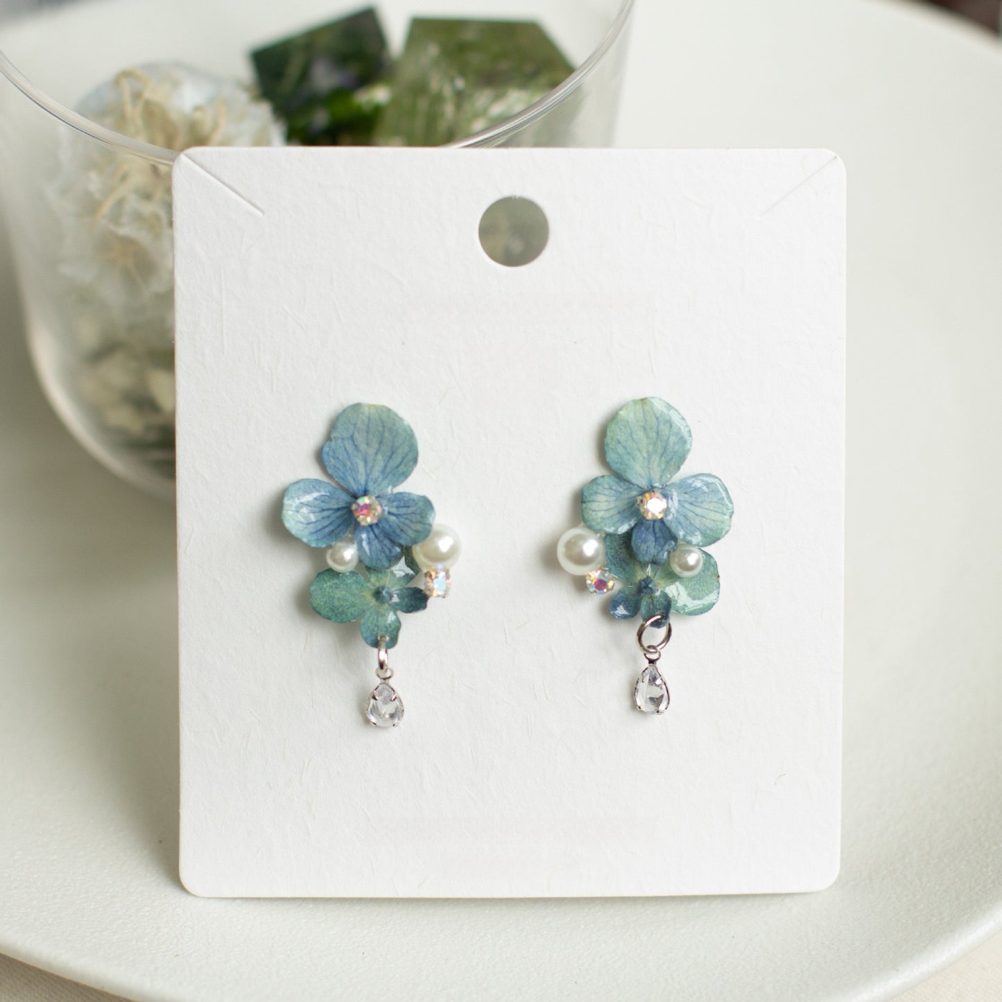 Hydrangea Blue hydrangea earrings with resin flower petals displayed on a jewellery card by Terra Decode