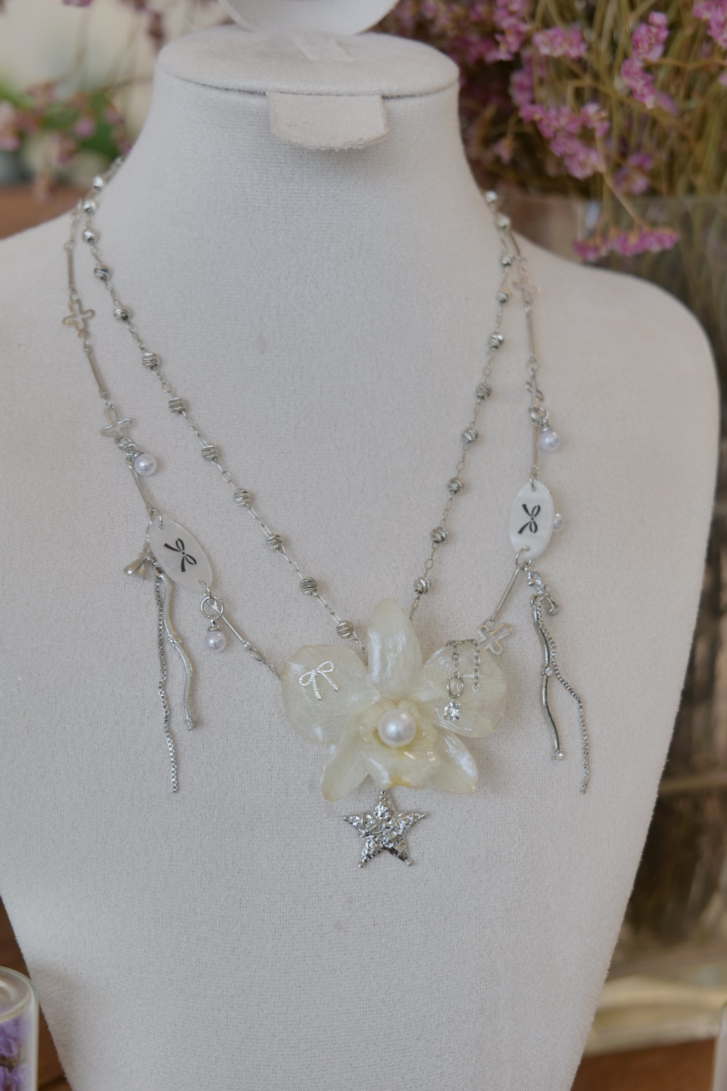 styled front view of cream Dendrobium orchid pearl necklace, handmade botanical jewellery by Terra Decode