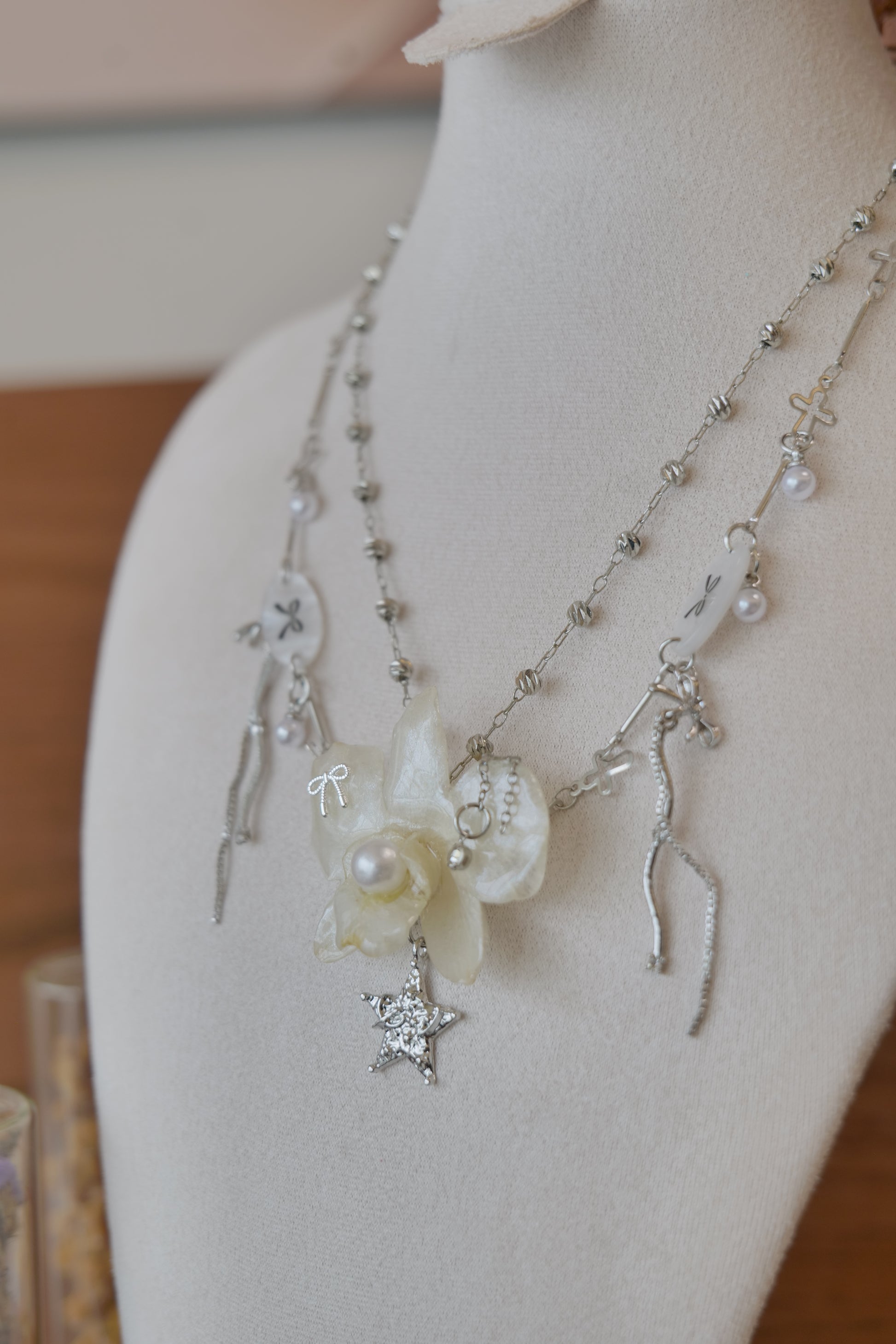 side view of cream Dendrobium orchid pearl necklace, handmade botanical jewellery by Terra Decode