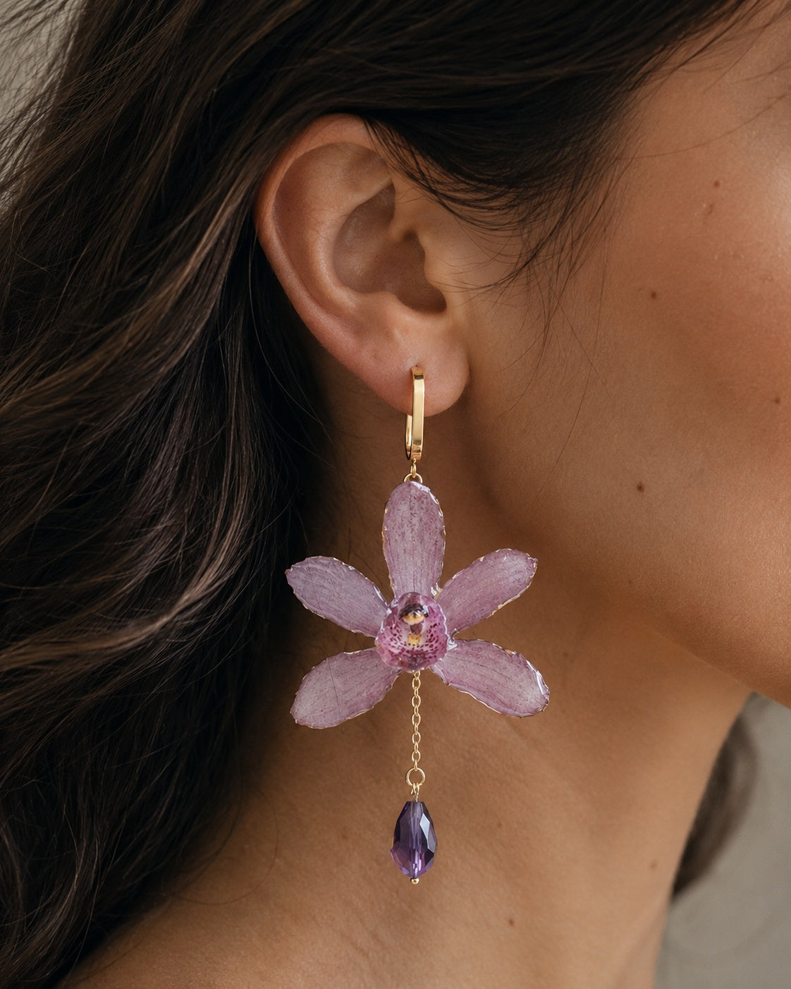 Model wearing soft purple Cymbidium orchid drop earrings with a faceted purple bead, Cymbidium Orchid Drop Earrings botanical jewellery by Terra Decode