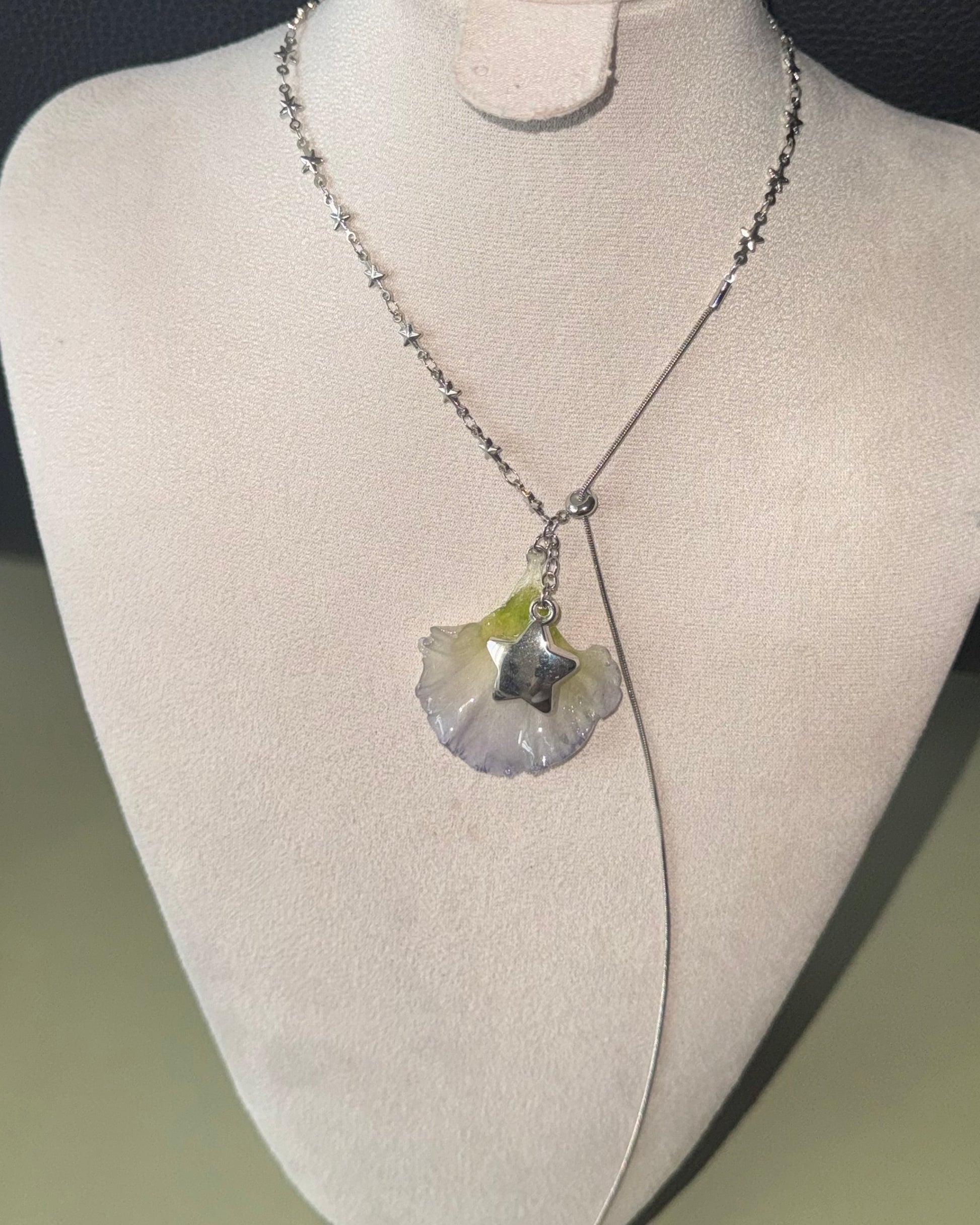Double-lisianthus petal lariat with silver-toned star charm shown from the front