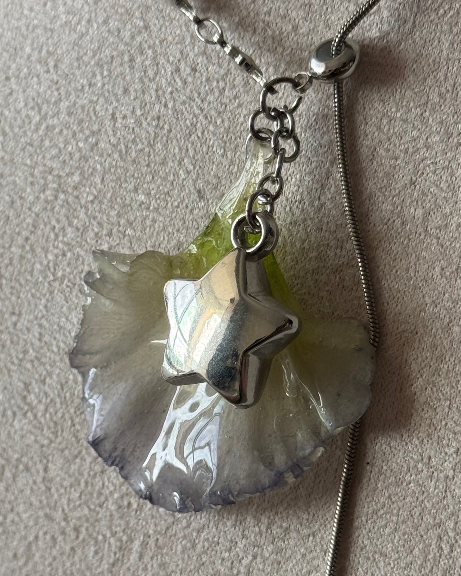 Close-up of pale green and lilac-edged lisianthus resin pendant