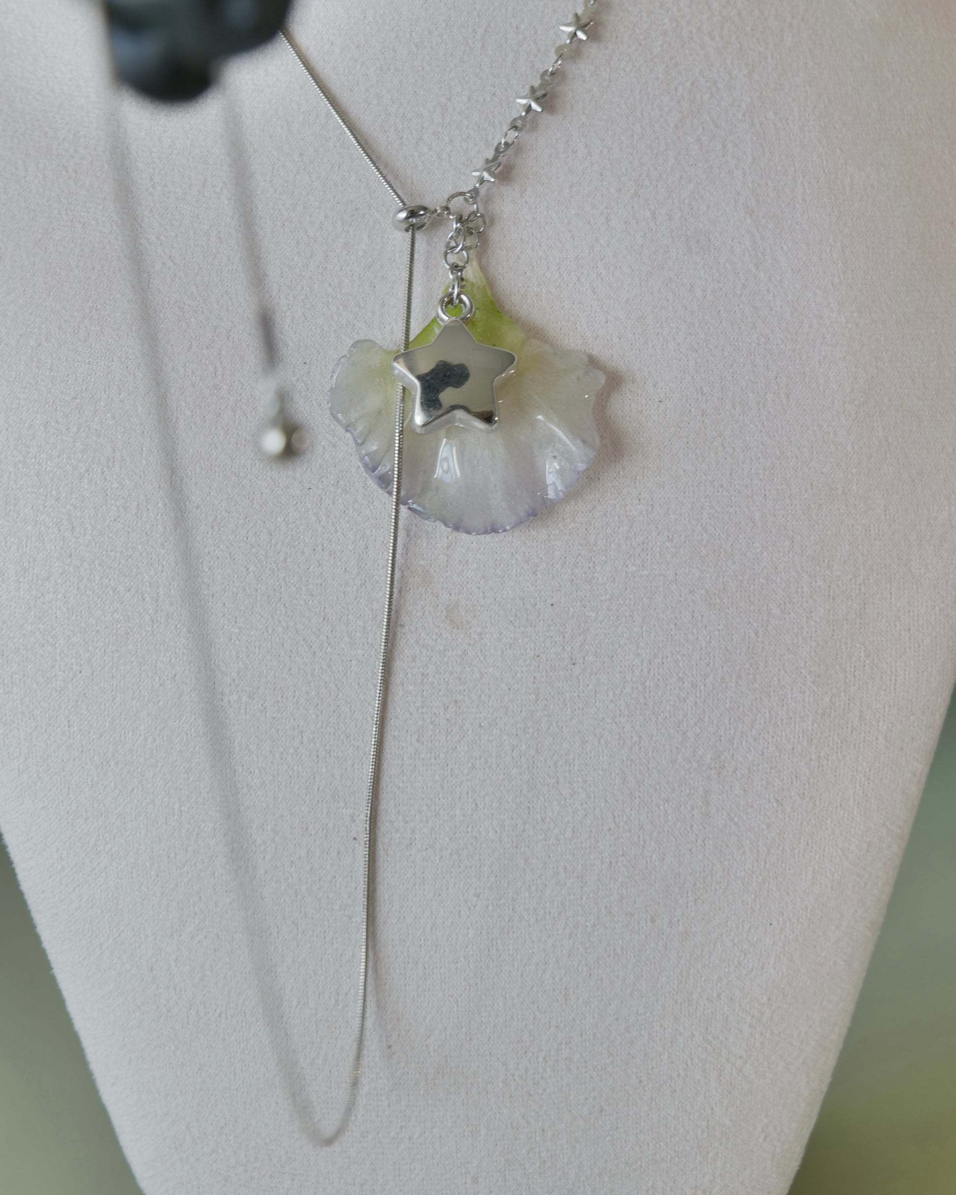 Adjusted lariat view showing the smooth-chain loop beneath the lisianthus pendant