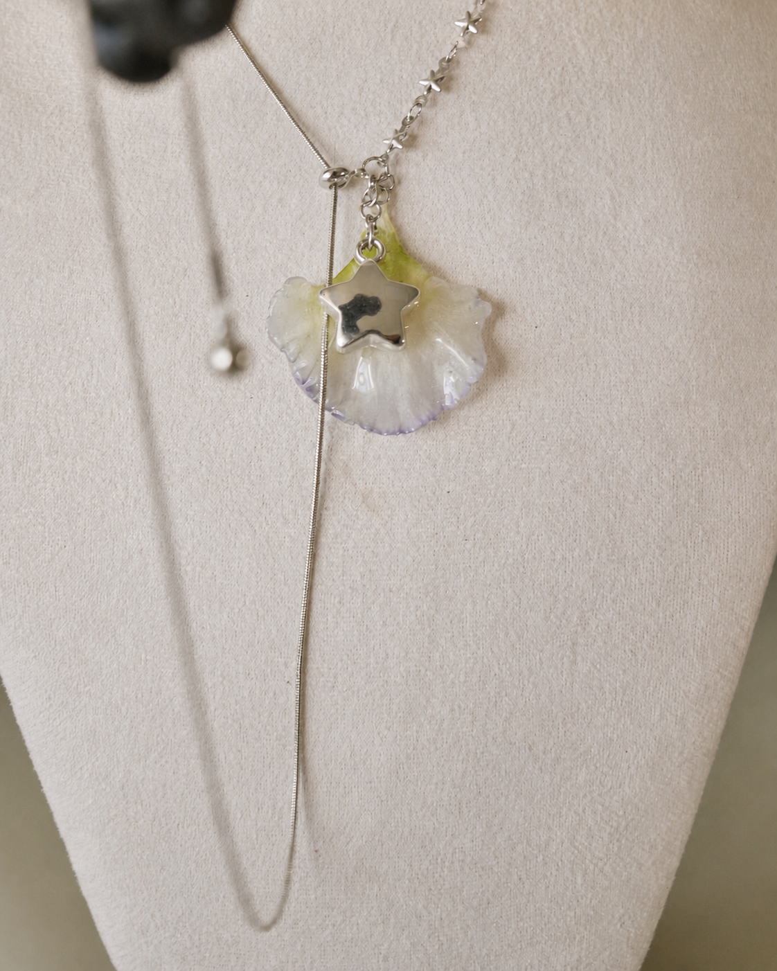 Detailed view of the adjustable lisianthus lariat necklace on a cream jewellery bust, Double Lisianthus Star Adjustable Lariat Necklace botanical jewellery by Terra Decode