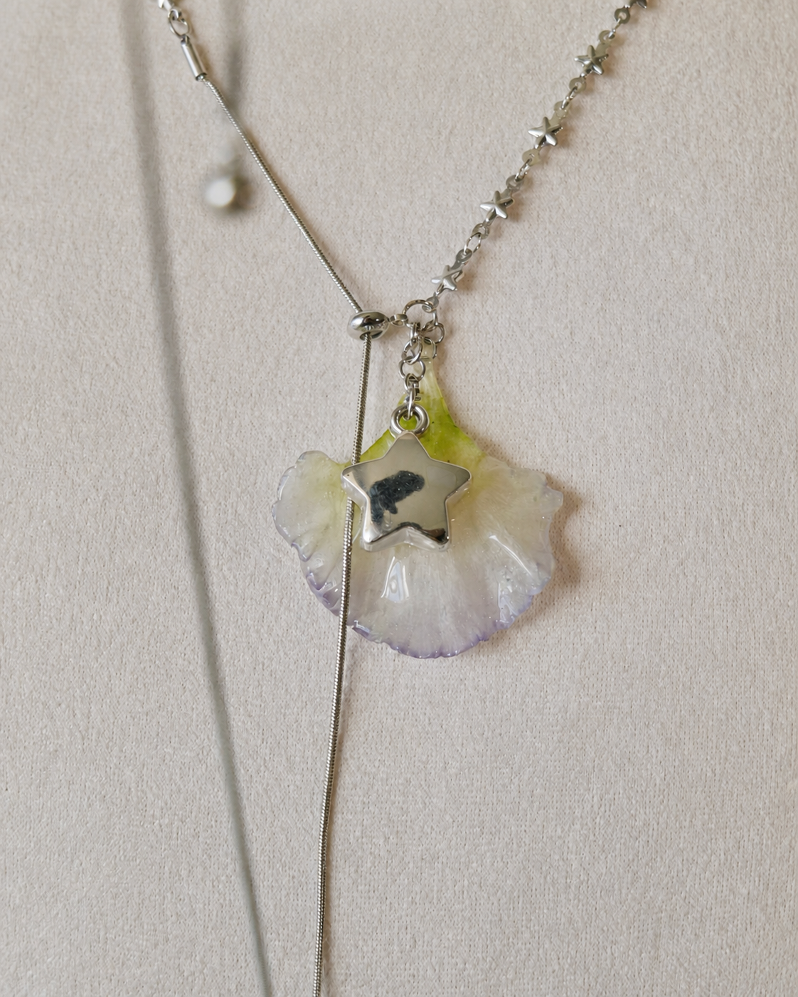 Close view of the preserved lisianthus petal and long silver-toned chain tail, Double Lisianthus Star Adjustable Lariat Necklace botanical jewellery by Terra Decode