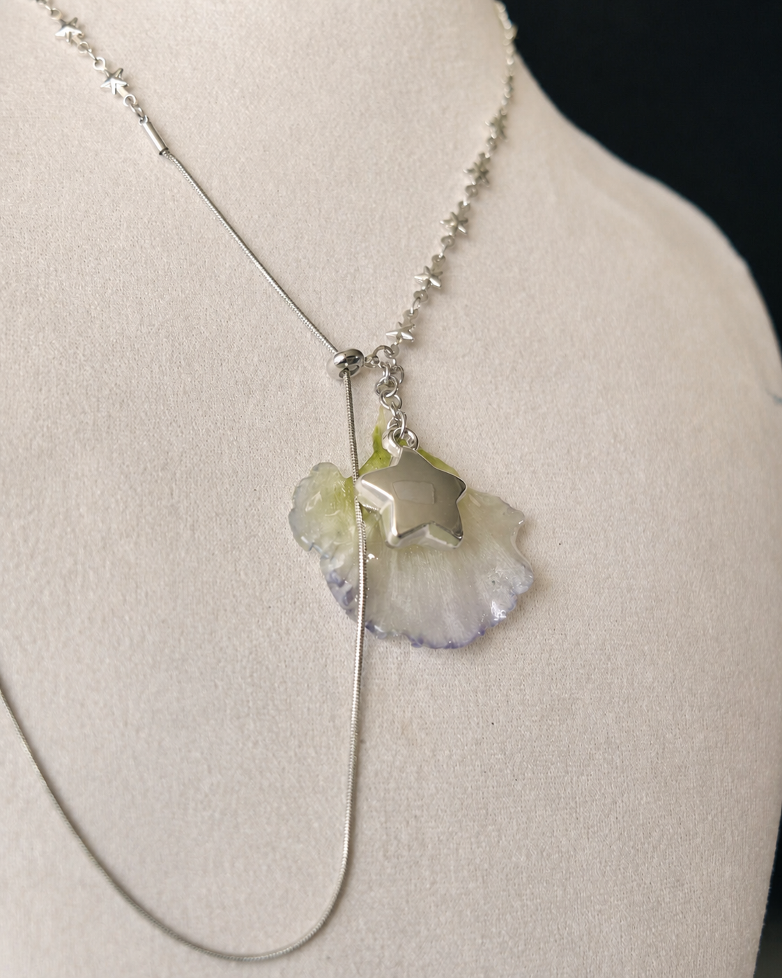 Alternate angle of the translucent flower pendant and star-shaped charm, Double Lisianthus Star Adjustable Lariat Necklace botanical jewellery by Terra Decode