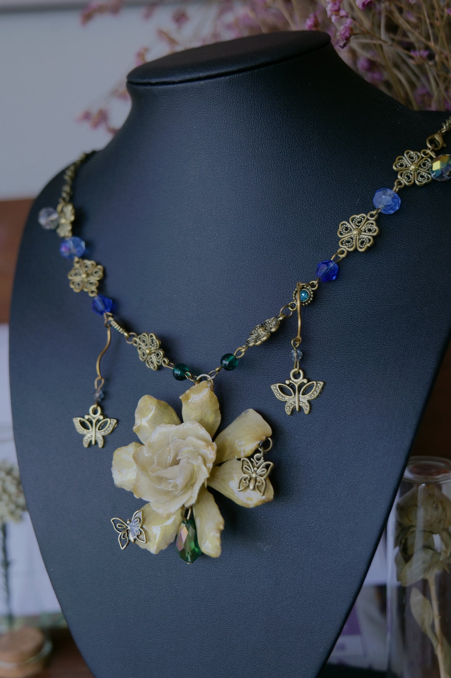 Antique-gold floral link and butterfly details on the gardenia necklace