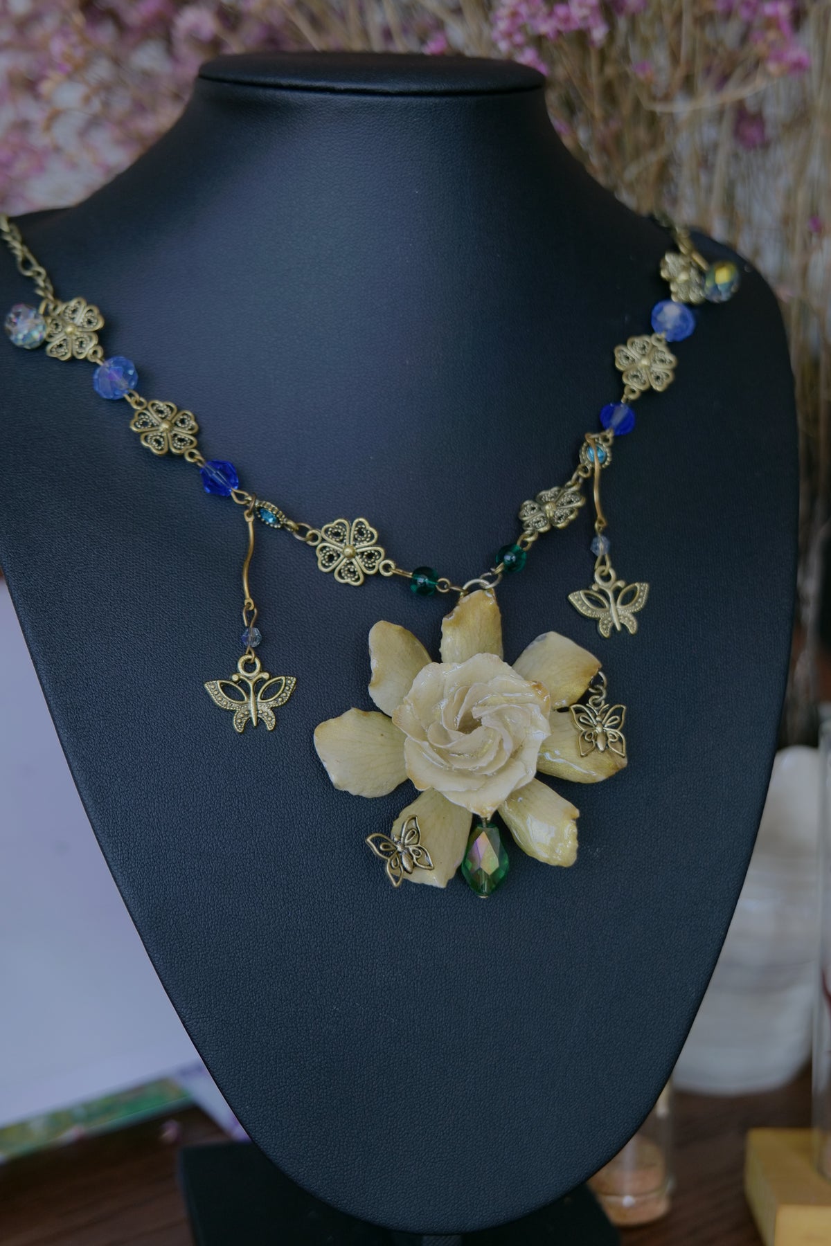 Full view of the one-of-a-kind preserved gardenia butterfly necklace