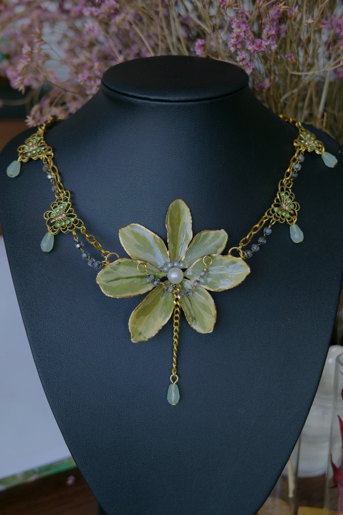 Close-up of pearl-style and pale-green drops beneath the golden-edge Euonymus leaves