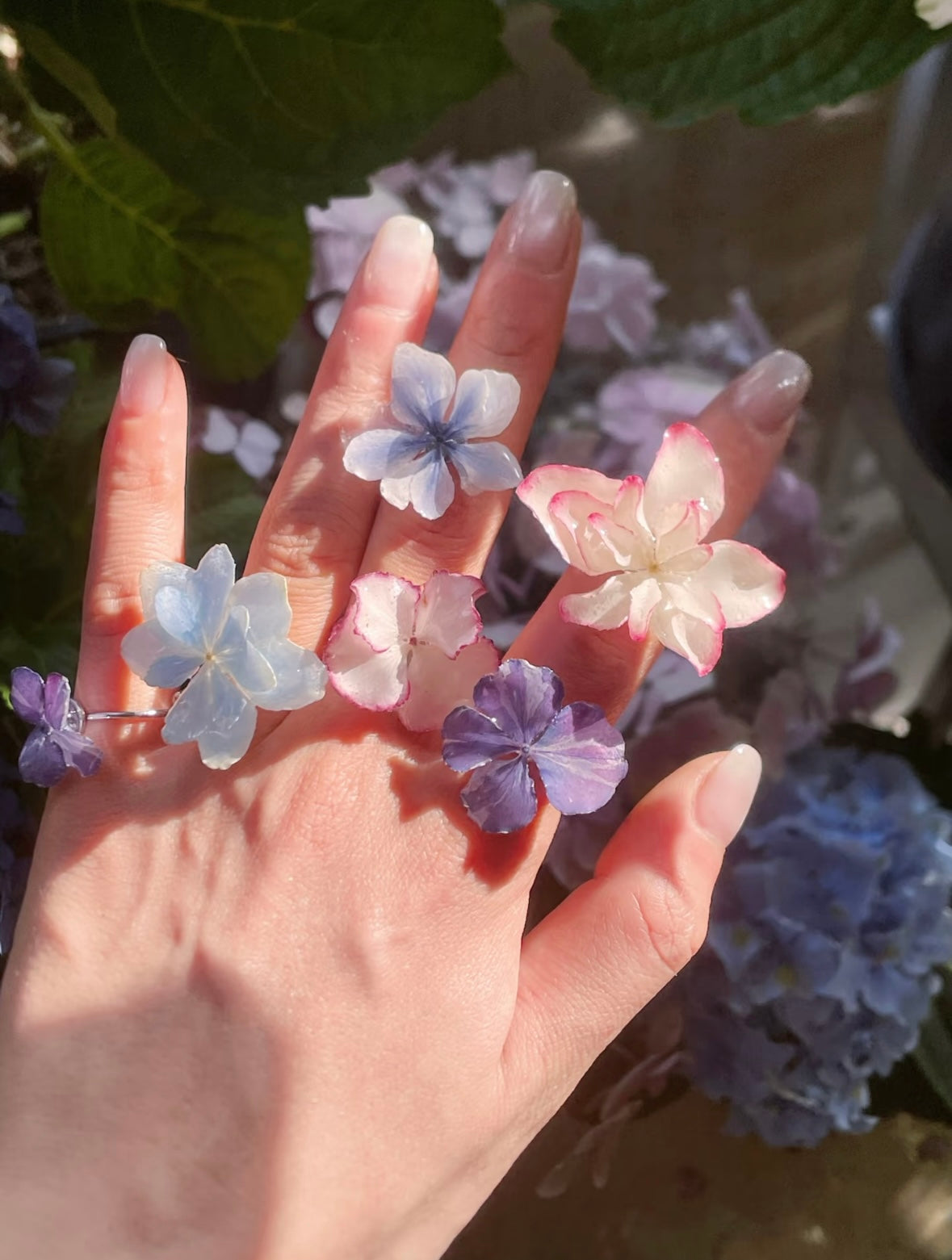 Hydrangea blue, soft pink and lavender hydrangea rings with resin petals worn on hand by Terra Decode