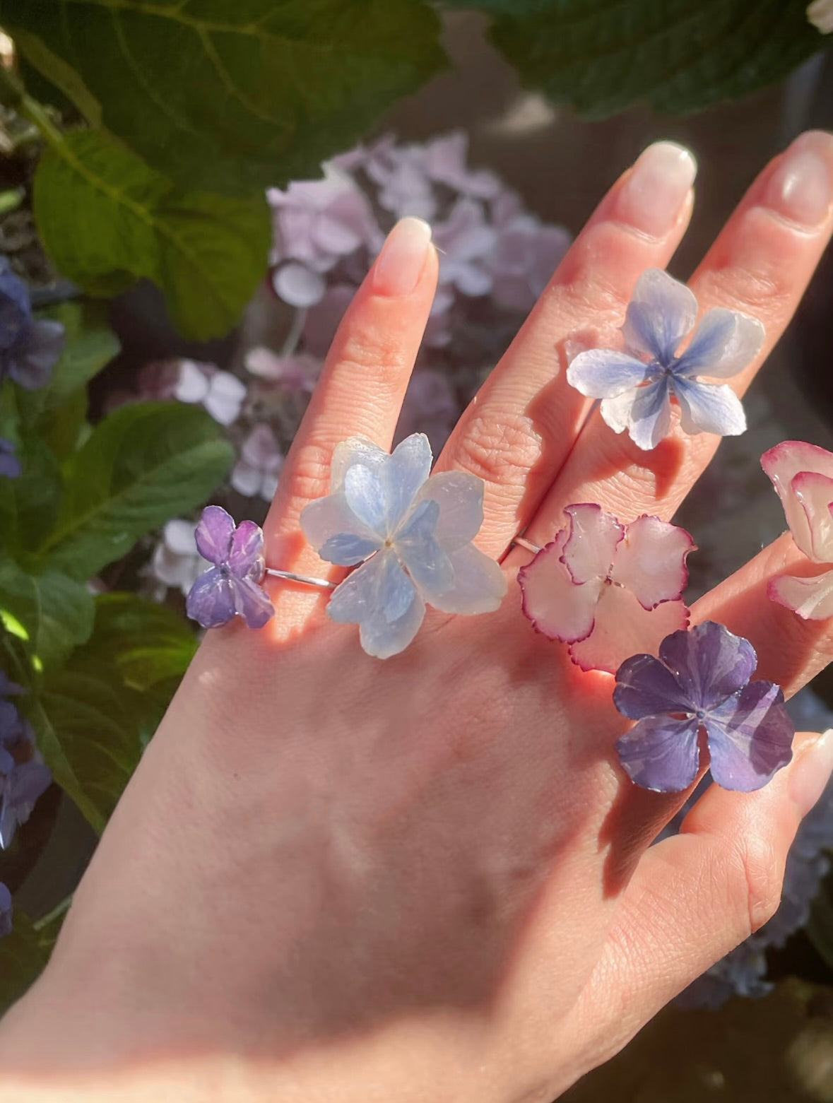 Hydrangea blue and lavender hydrangea rings with translucent resin petals worn on hand by Terra Decode