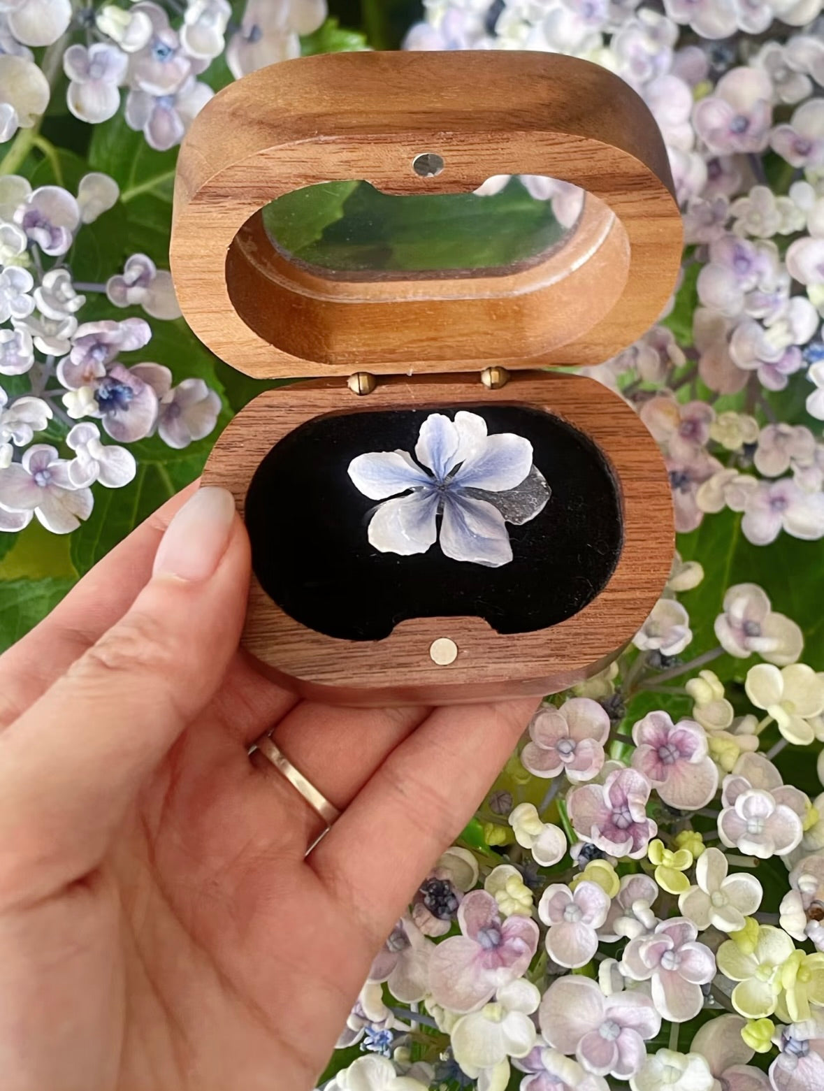Hydrangea blue ring with resin petals displayed in a wooden jewellery box among hydrangea flowers by Terra Decode