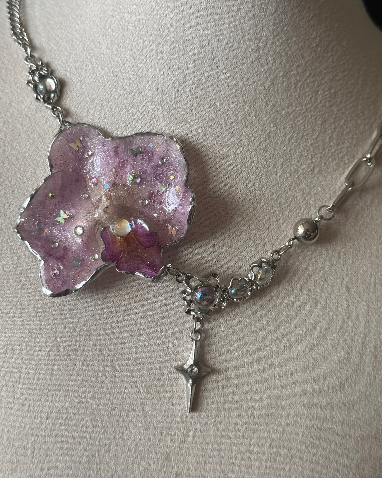 Close-up of lilac phalaenopsis resin pendant and moonstone-accented chain