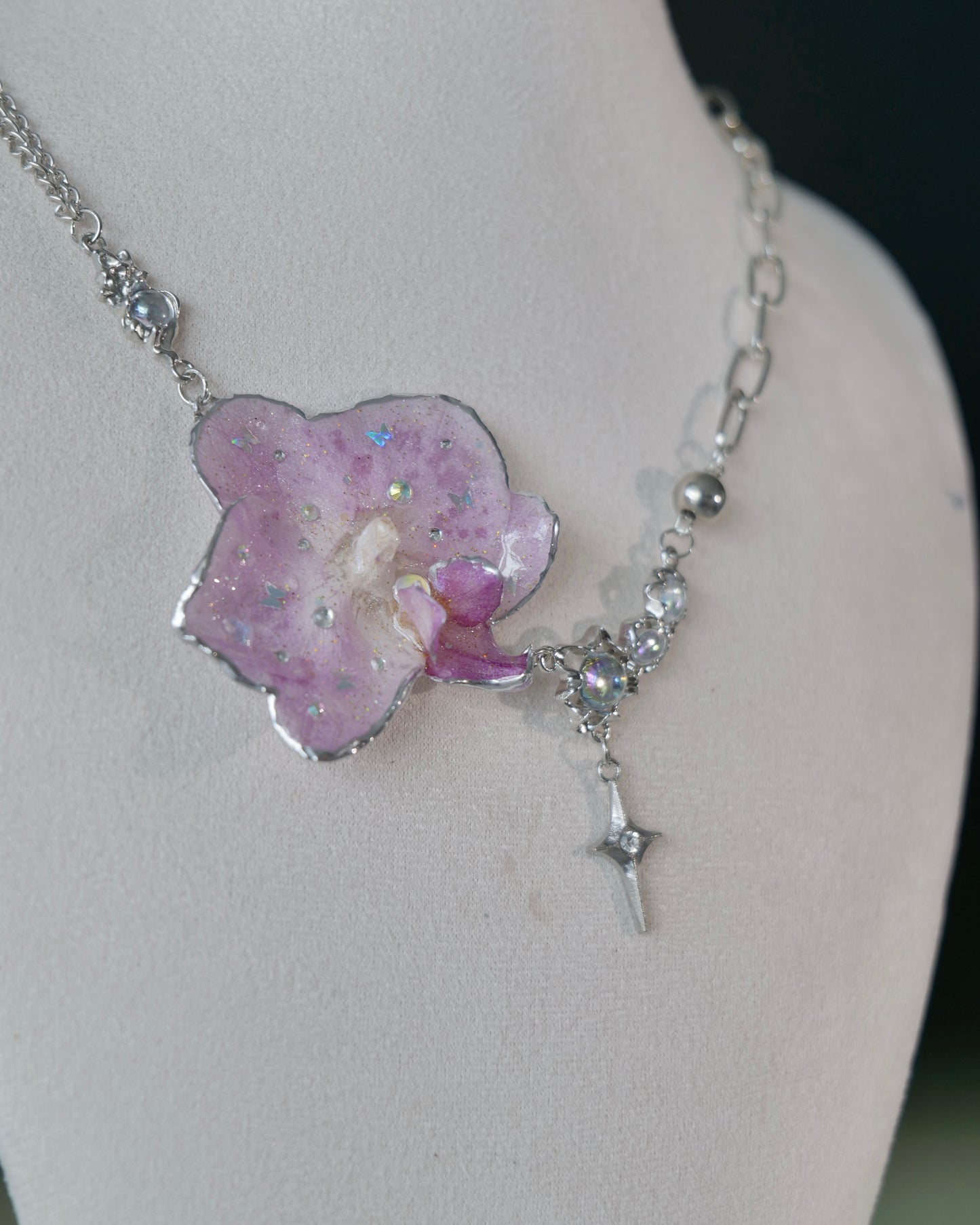 Side angle of lilac orchid pendant with iridescent accents and star drop