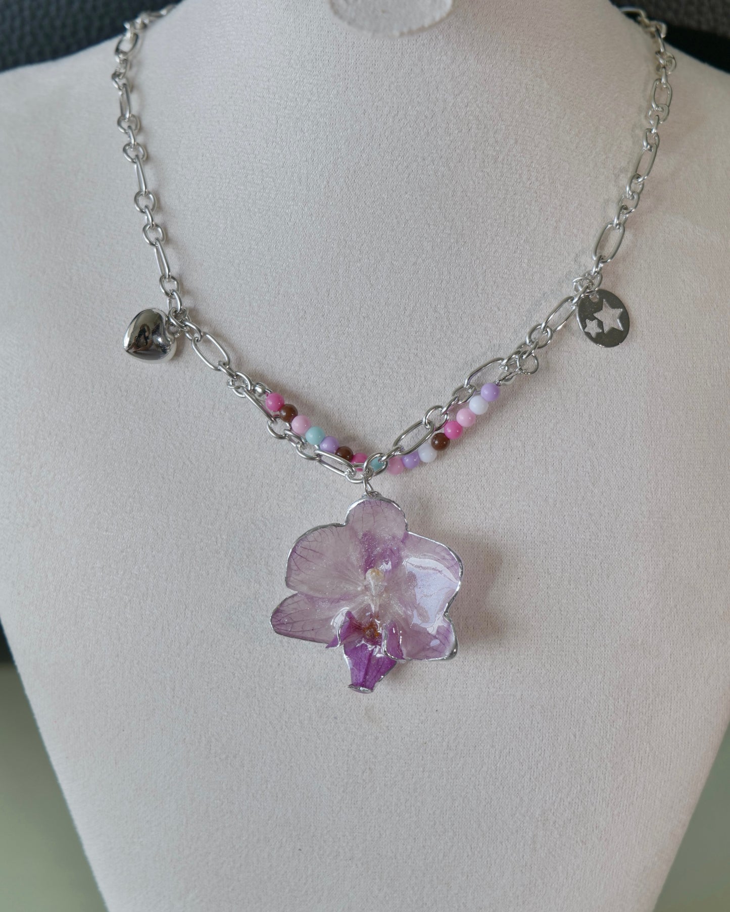 Natural-light front view of lilac Phalaenopsis necklace with pastel beads