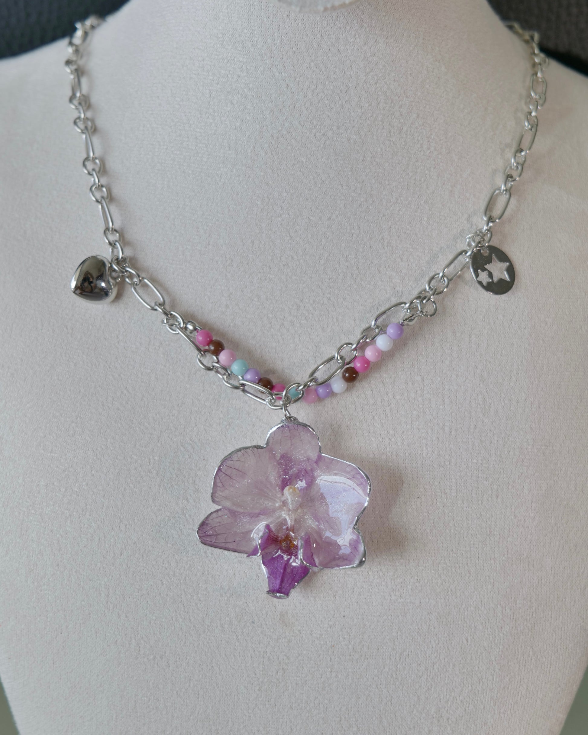Front view showing lilac orchid pendant, heart and star-cutout charms