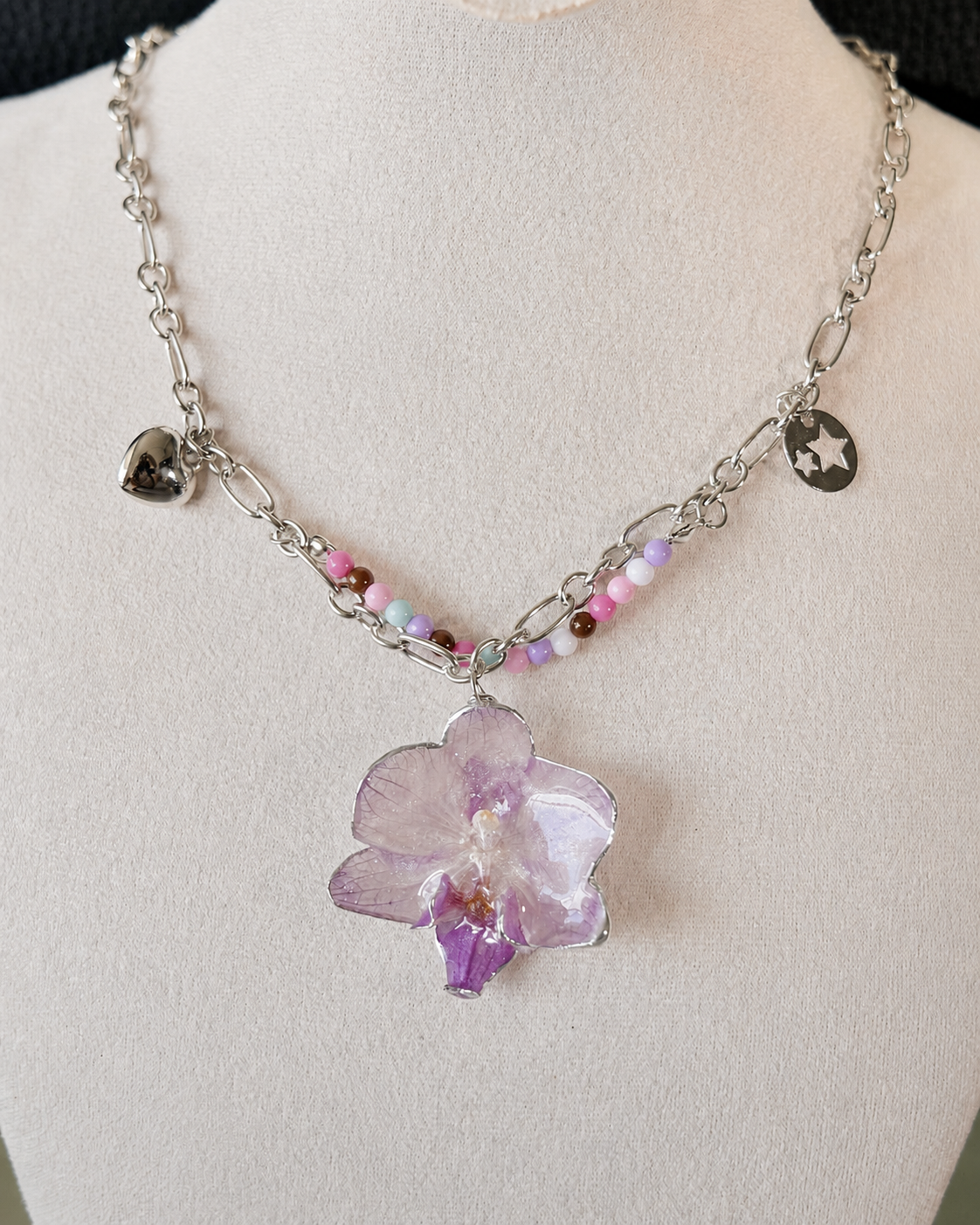 Detailed view of the orchid necklace with silver-toned heart and star-cutout charms, Lilac Phalaenopsis Pastel Bead Charm Necklace botanical jewellery by Terra Decode