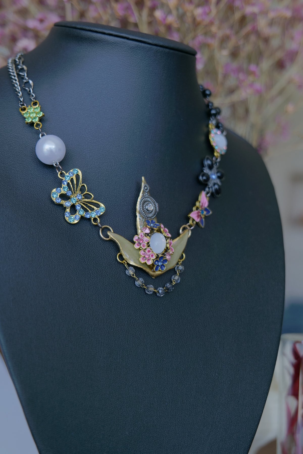 Close-up of butterfly, floral and pearl-style details around the Nandina leaves