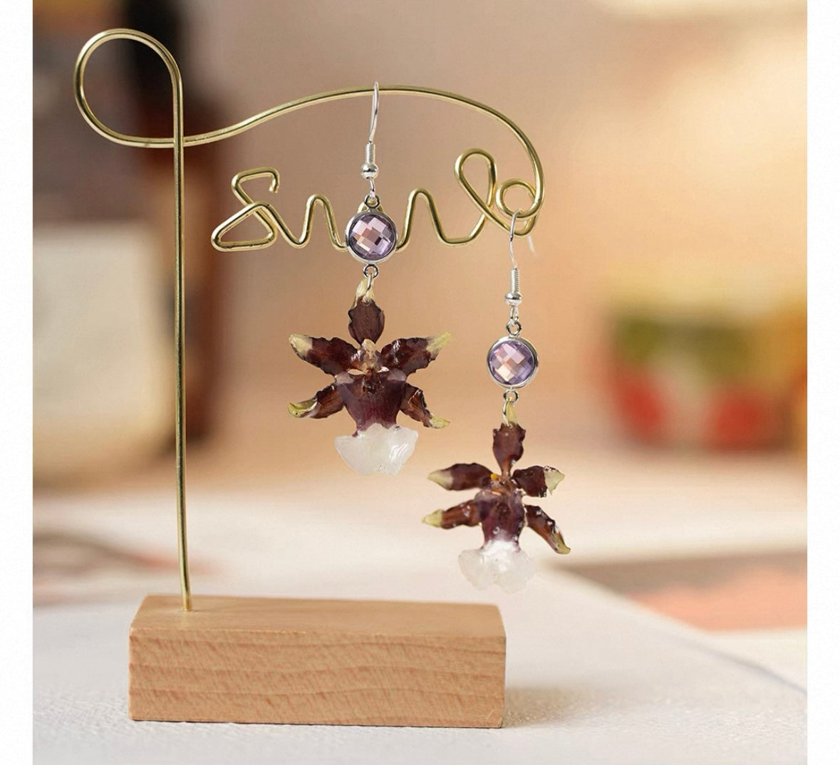 Deep plum oncidium orchid earrings with resin petals and book styling by Terra Decode
