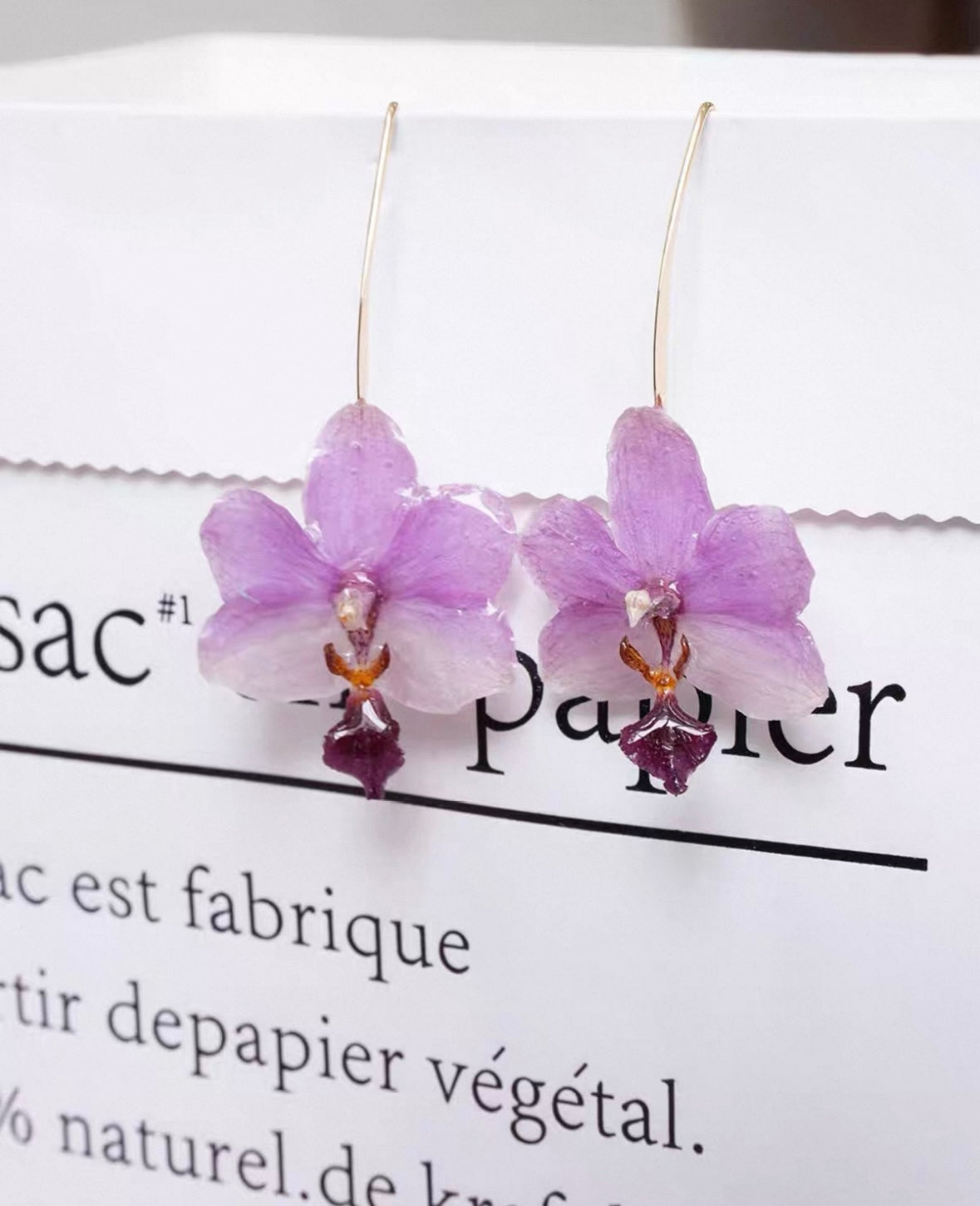 Soft purple orchid ear hook earrings with resin petals and white cup styling by Terra Decode