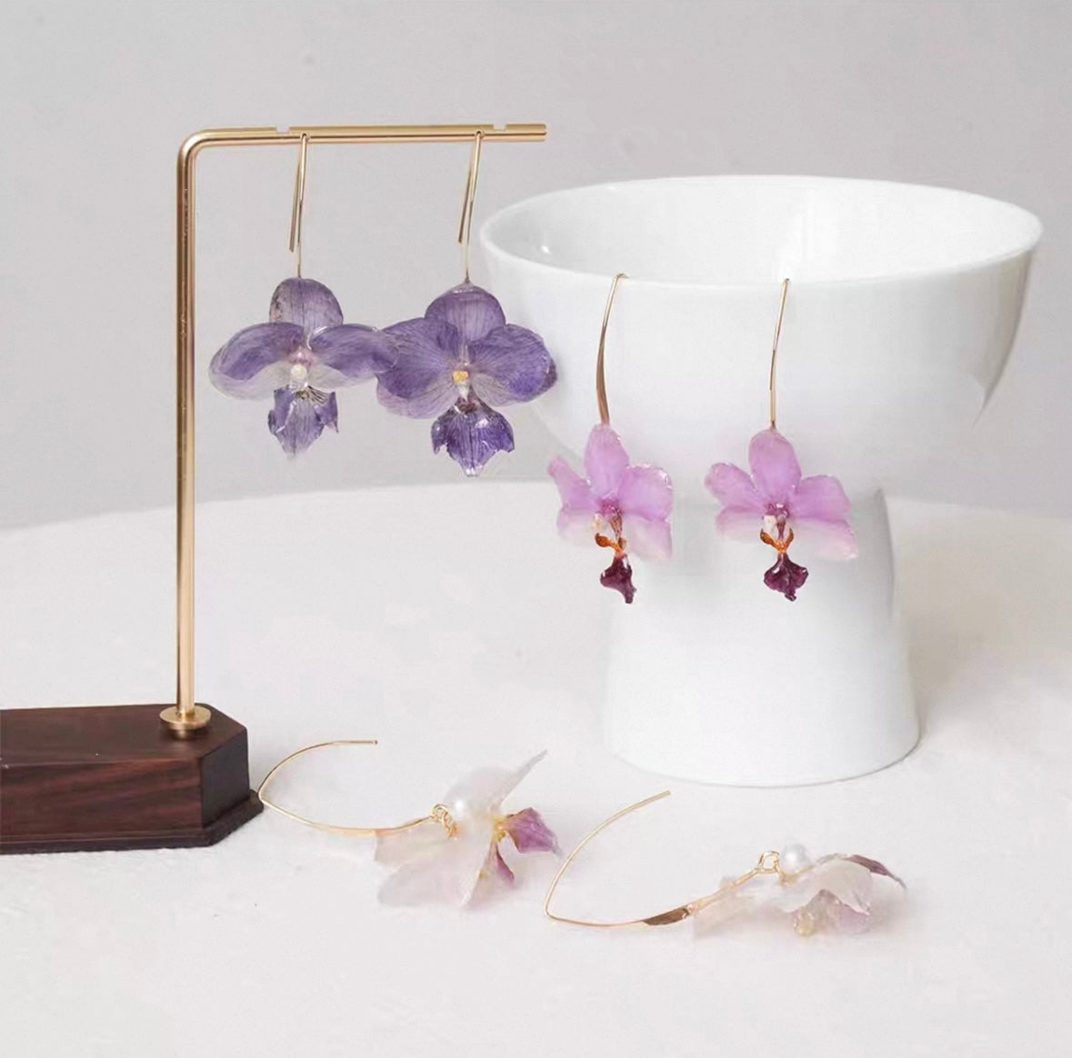 Soft purple orchid ear hook earrings with resin petals and warm white styling by Terra Decode