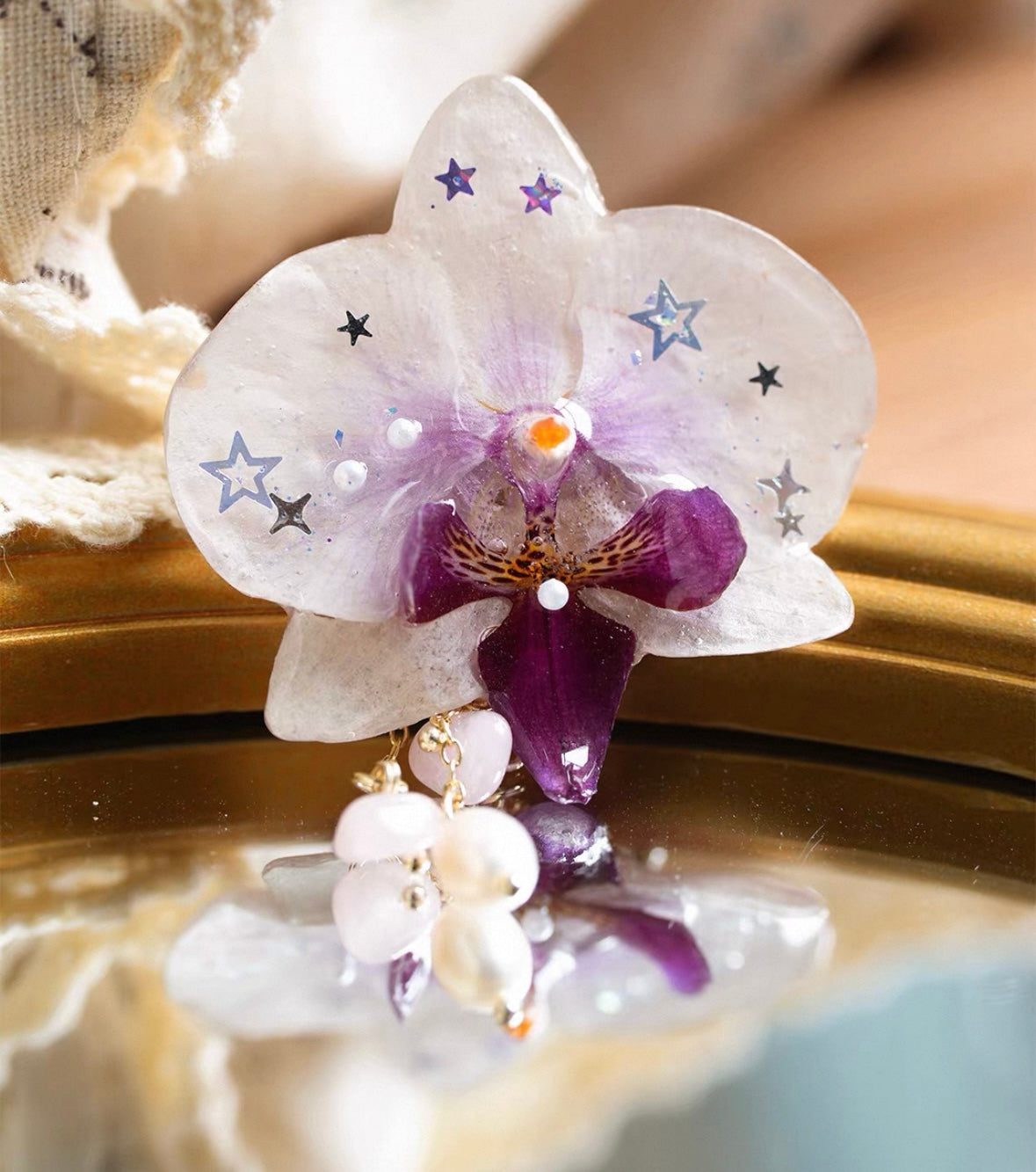 Star detail orchid brooch with resin petals and pearl-like movement by Terra Decode