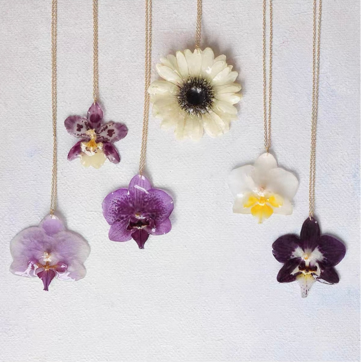 Orchid flower pendant necklace variations with resin blooms and gold-tone chains by Terra Decode