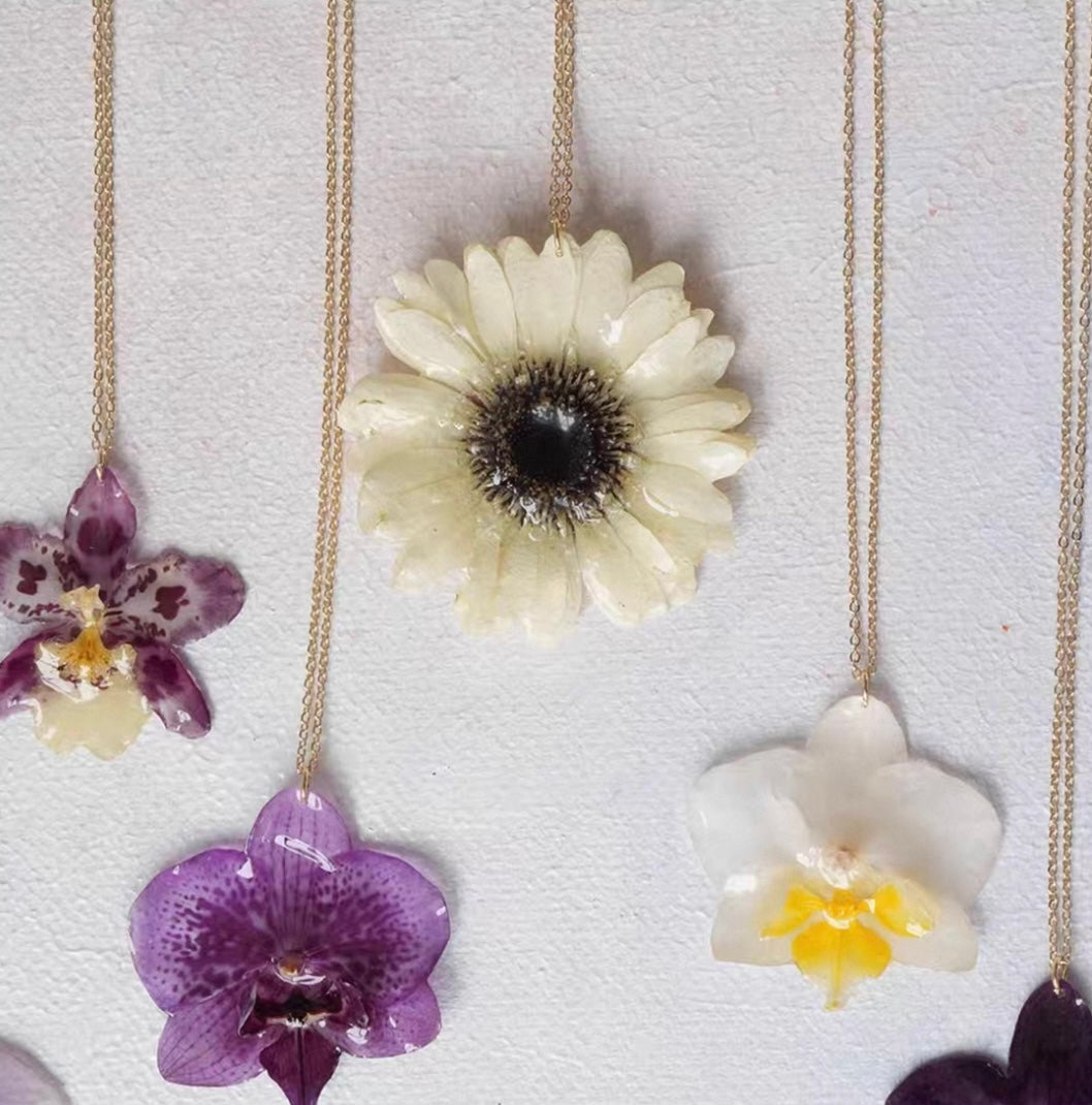 Orchid and cream botanical flower pendant necklaces with resin petals and gold-tone chains by Terra Decode