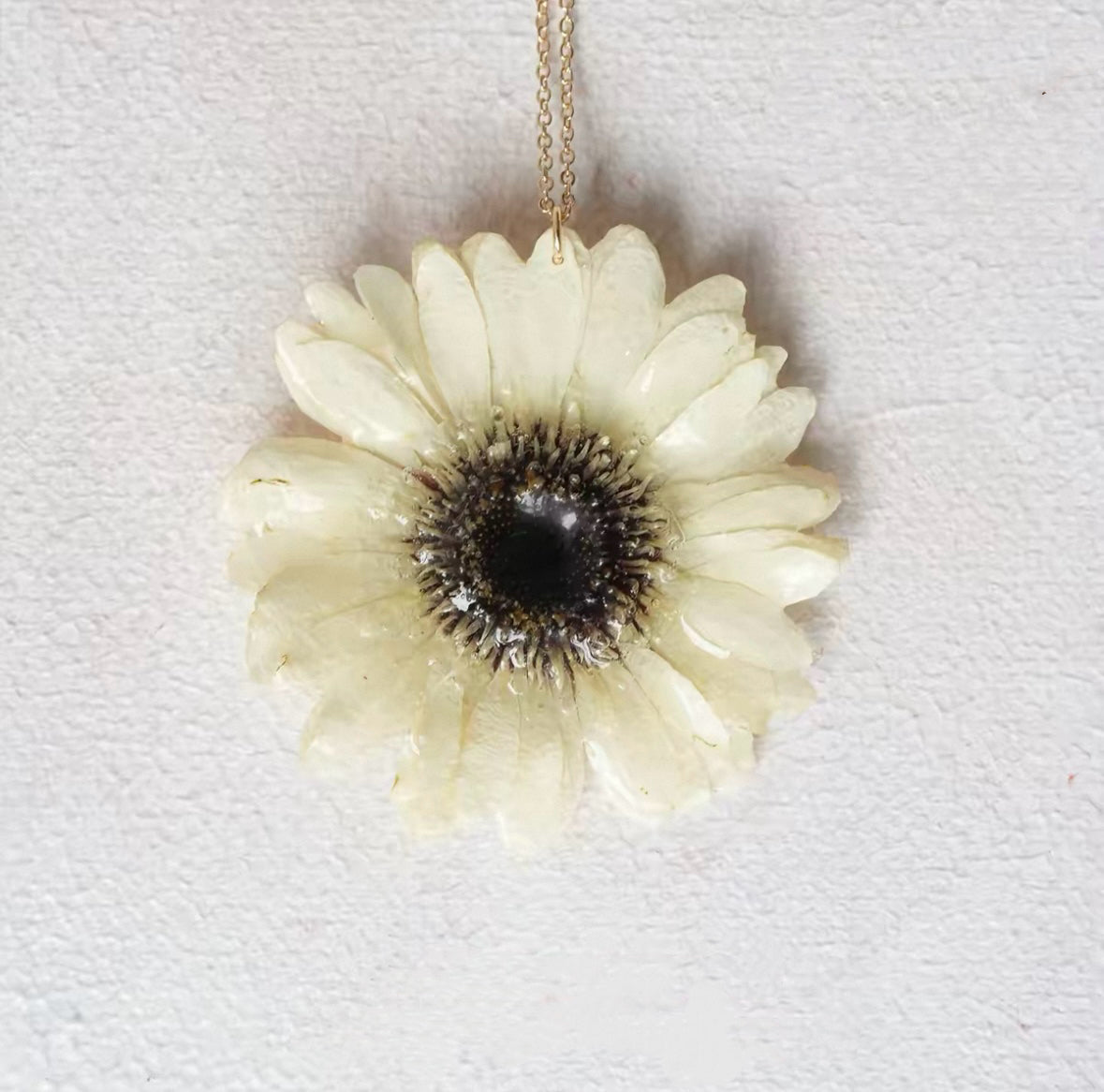 Cream daisy-style flower pendant necklace with resin petals and gold-tone chain by Terra Decode