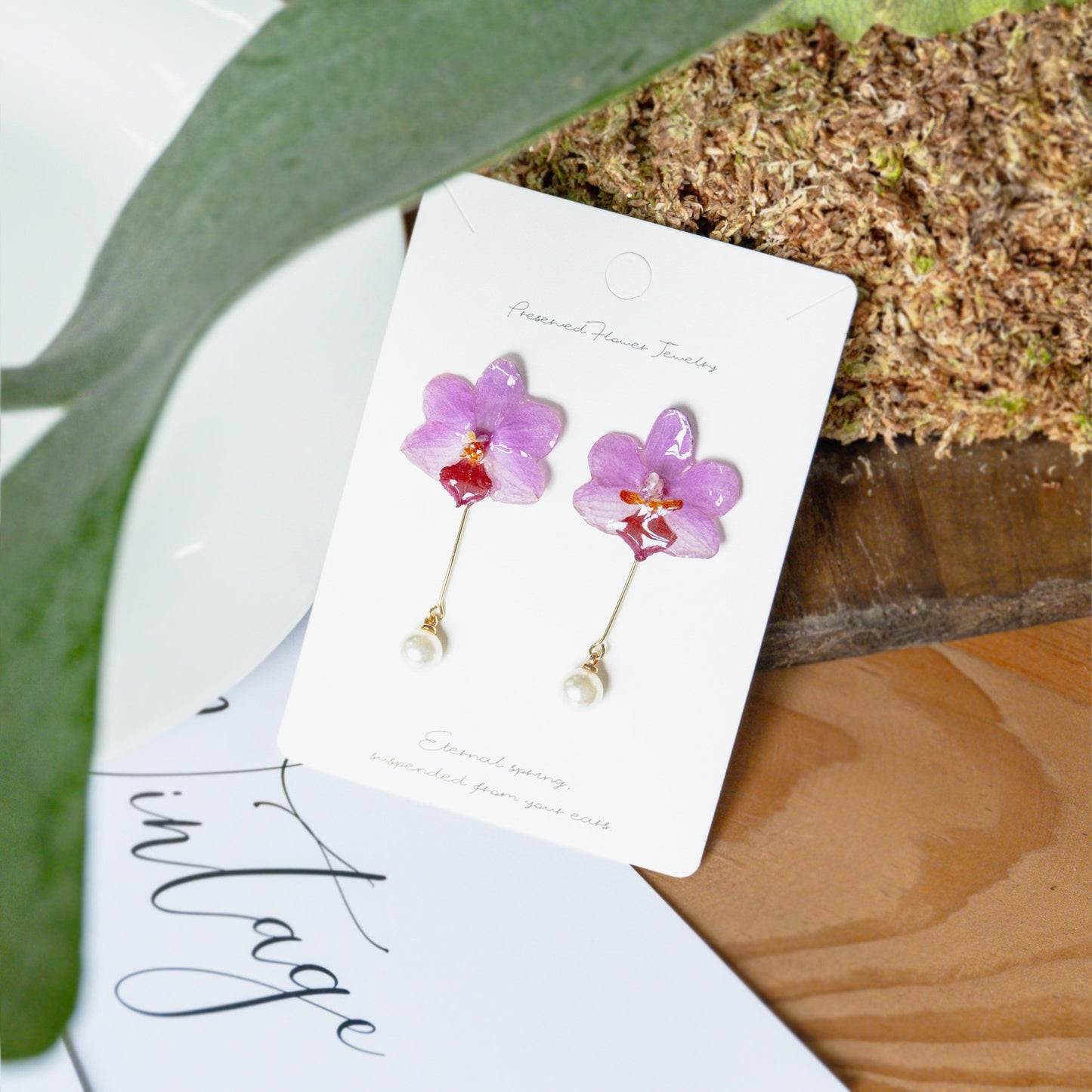 Soft pink orchid earrings with resin flower petals and botanical styling by Terra Decode