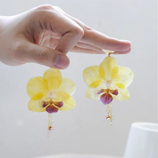 Butter Yellow orchid earrings with large resin flower petals and gold-tone hooks by Terra Decode