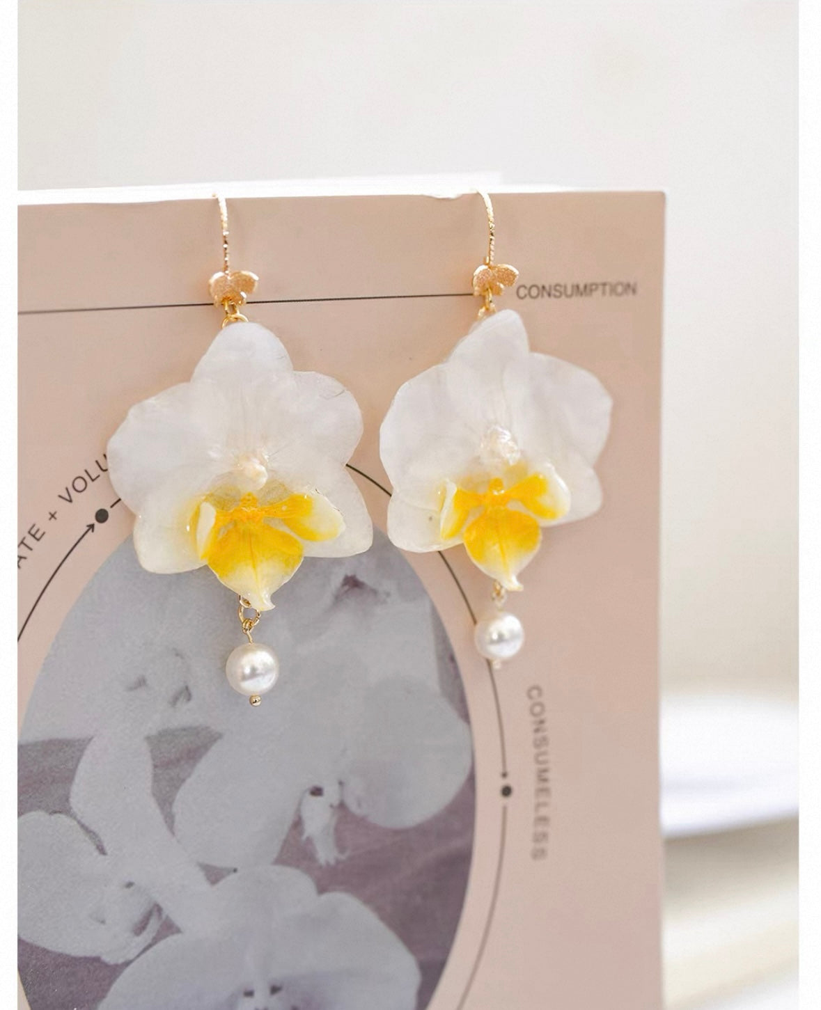 Cream white orchid earrings with resin flower petals and pearl-like drops by Terra Decode