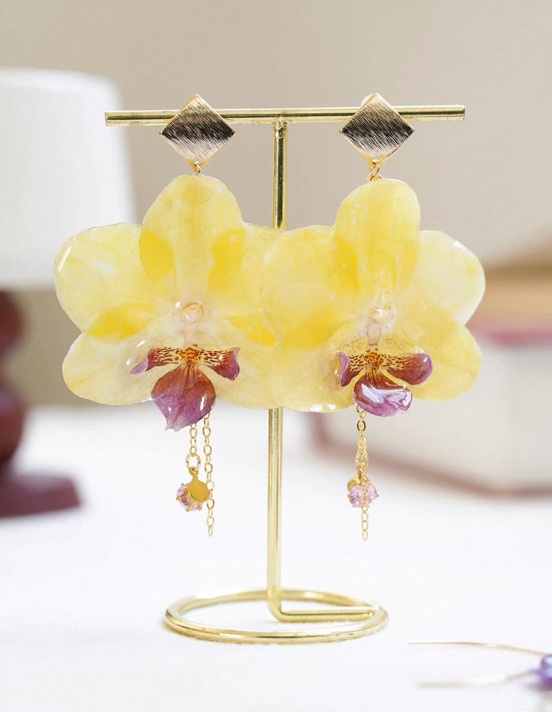 Butter Yellow orchid earrings with large resin petals on display stand by Terra Decode