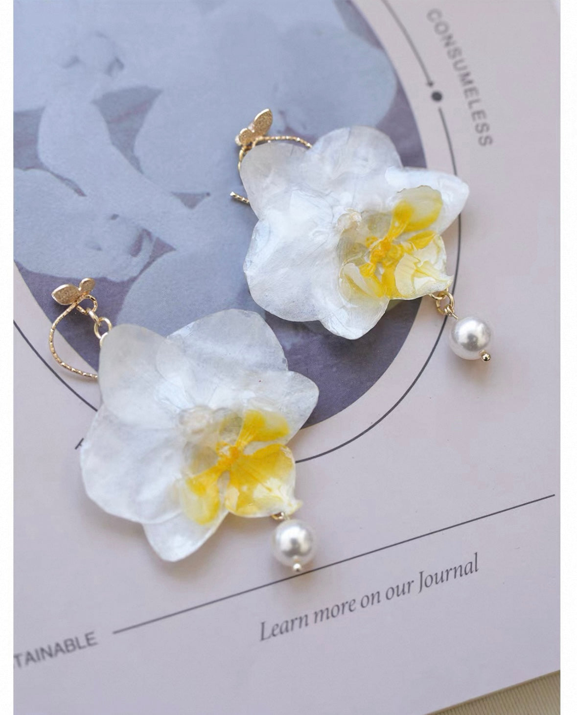 Cream white orchid earrings with resin flower petals and book styling by Terra Decode