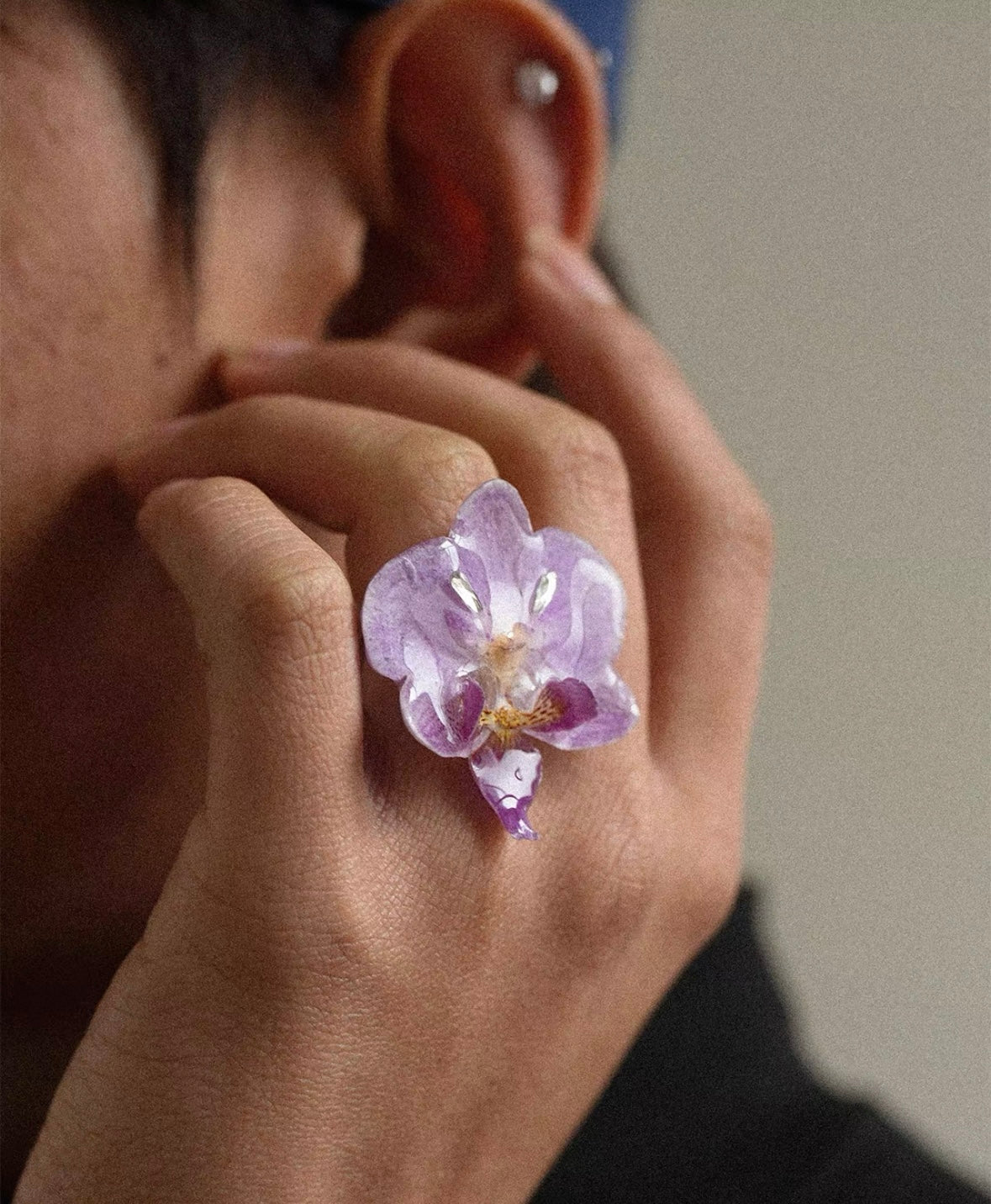 Soft purple orchid statement ring with resin petals worn near face by Terra Decode