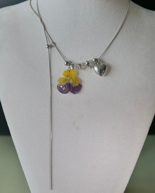 Yellow and purple pansy lariat necklace with heart charm shown from the front