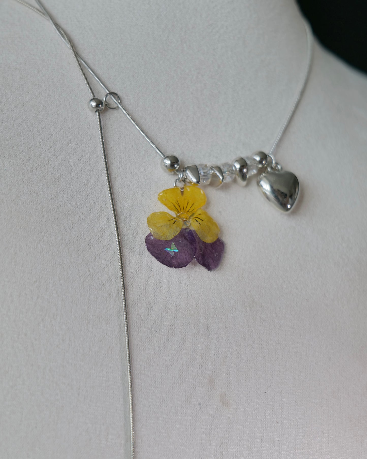 Natural-light view of preserved pansy necklace with sliding chain construction