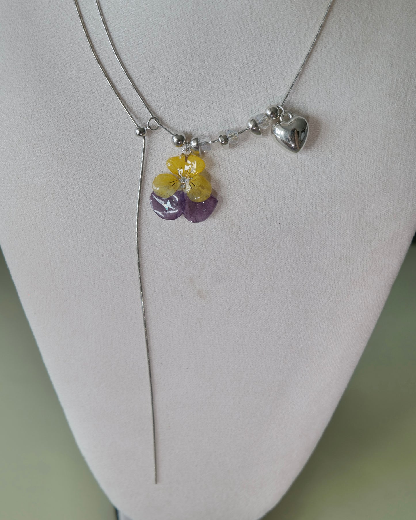 Angled view of the Pansy Heart Adjustable Lariat Necklace showing its long chain drop