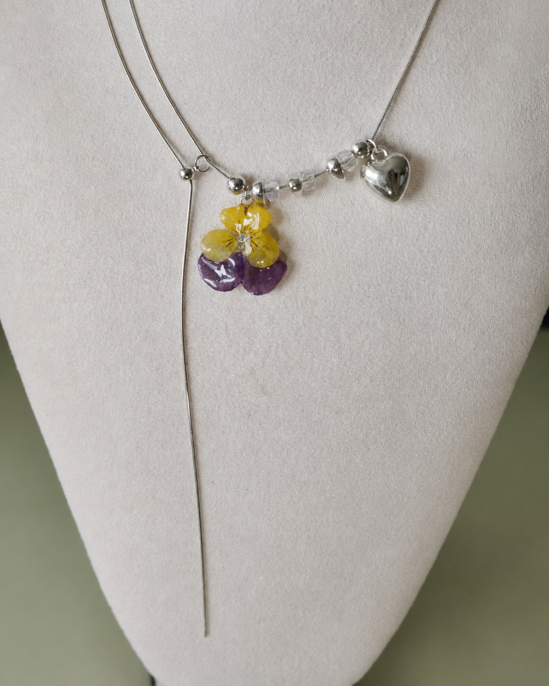 Alternate angle of the preserved pansy pendant and long sliding chain drop, Pansy Heart Adjustable Lariat Necklace botanical jewellery by Terra Decode