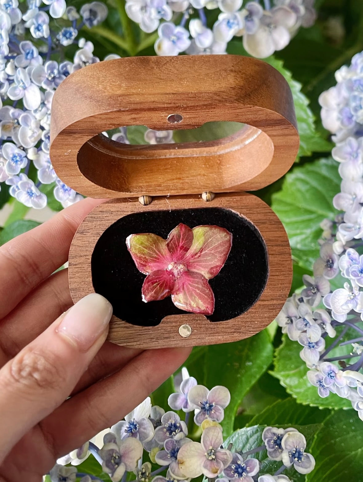 Soft pink hydrangea ring with resin flower petals displayed in a wooden box by Terra Decode
