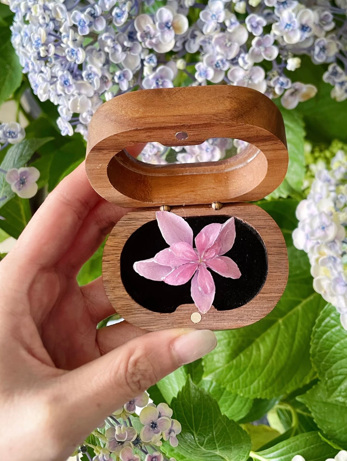 Soft pink hydrangea ring with resin flower petals in botanical packaging by Terra Decode