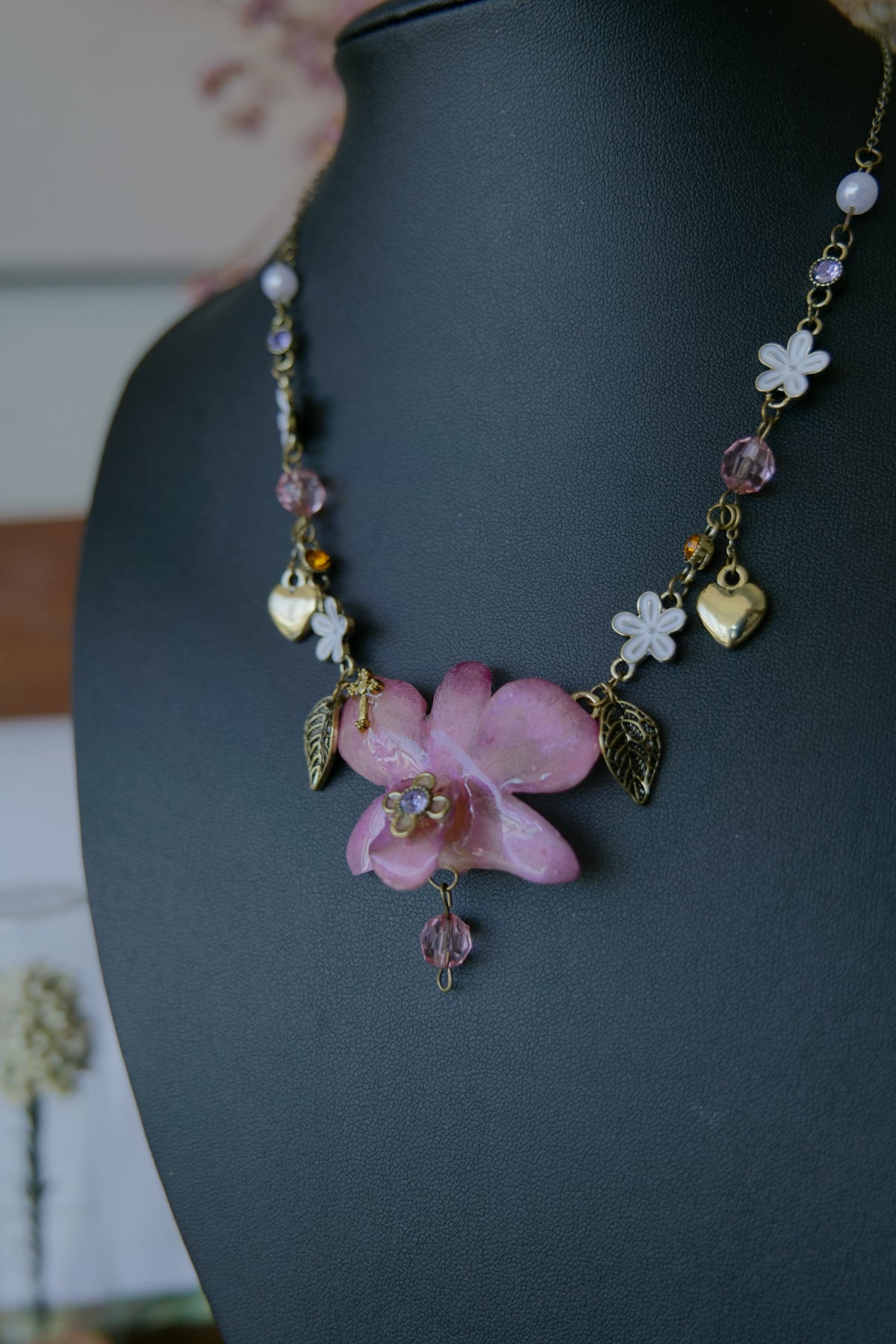 Styled view of pink-purple Dendrobium necklace with pearl-style beads and pink crystal details
