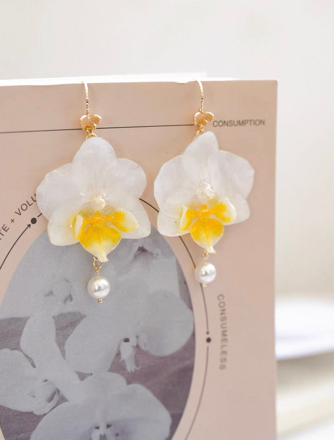 Cream Pearl Drop orchid earrings with resin petals and pearl-like drop by Terra Decode